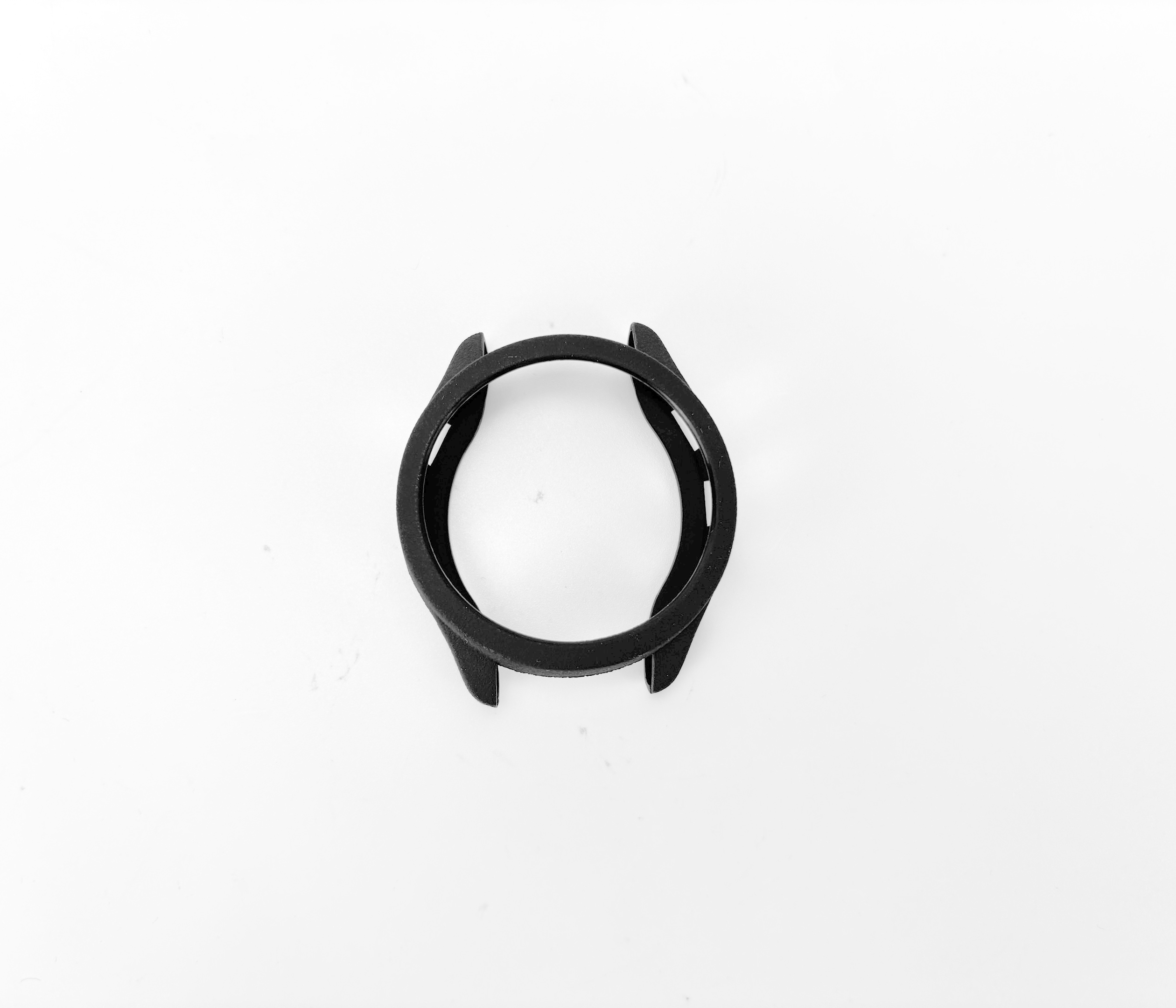 Una lunetta nera per orologio è centrata su una superficie bianca. La lunetta è circolare e ha un bordo rialzato.