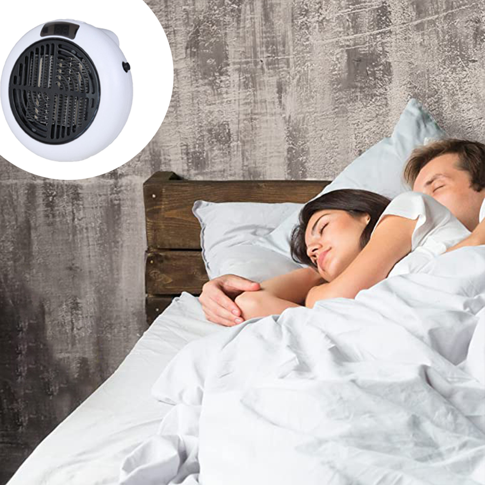 Ein Paar schläft im Bett. Ein weißer Heizlüfter ist in der Ecke. Grau strukturierte Wand. Weiße Bettwäsche und Kissen.