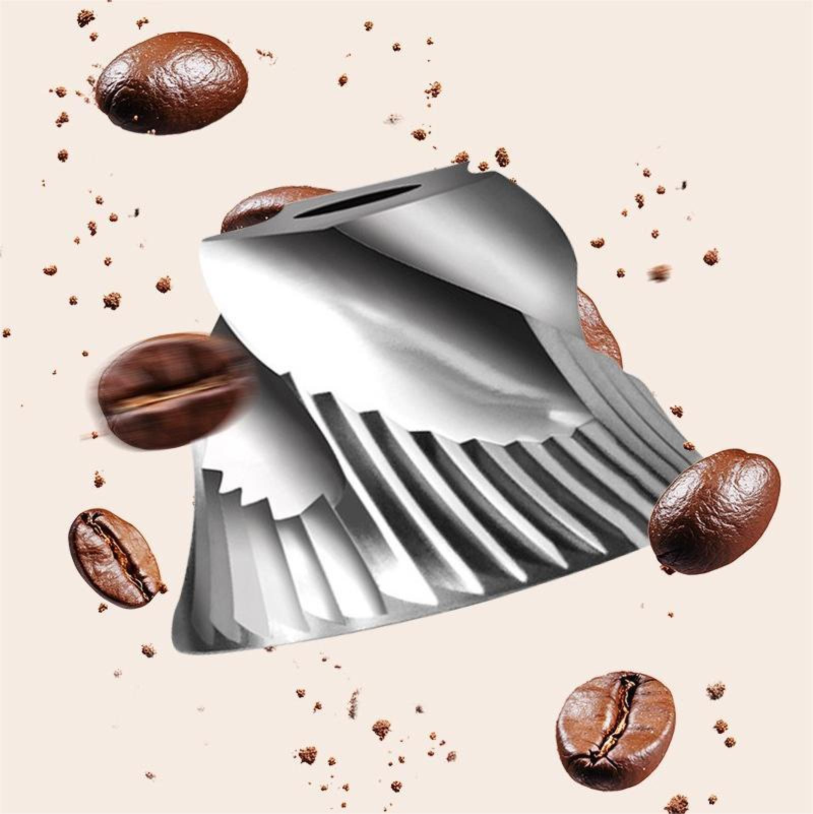 Eine Kaffeemühle aus Metall mit Kaffeebohnen und -satz, die herumschweben. Der Hintergrund ist hellbeige.