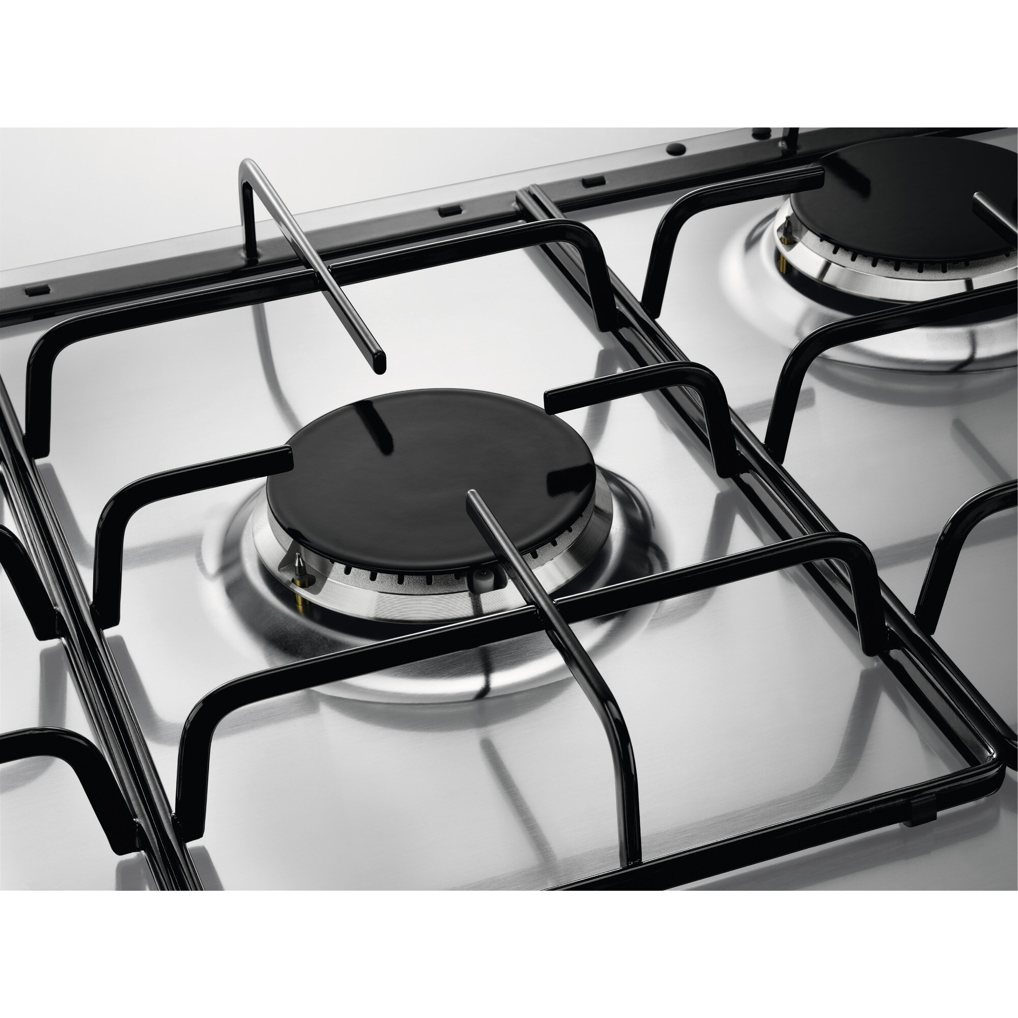 Primer plano de una estufa de gas de acero inoxidable con rejillas y tapas de quemador negras. Superficie reflectante.