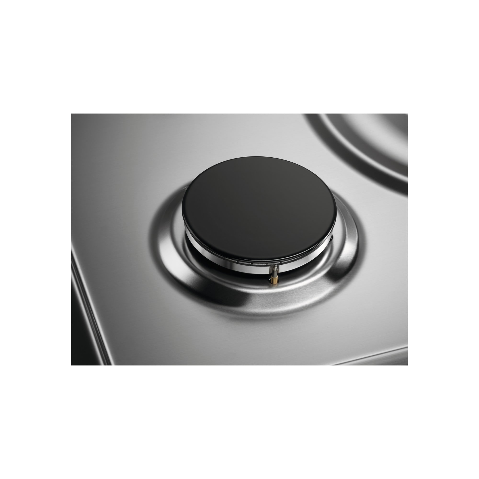 Zbliżenie palnika kuchenki gazowej. Palnik jest czarny i okrągły, osadzony na błyszczącej, srebrnej powierzchni.