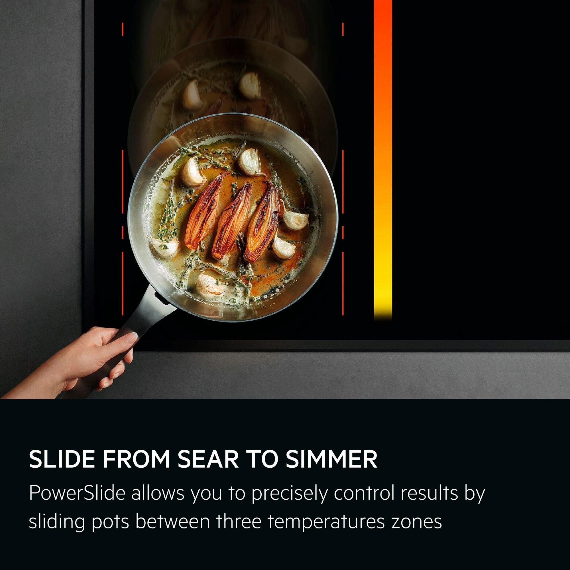 Ręka trzyma patelnię z ugotowanym jedzeniem. Patelnia jest na czarnej kuchence z pomarańczowymi wskaźnikami temperatury.