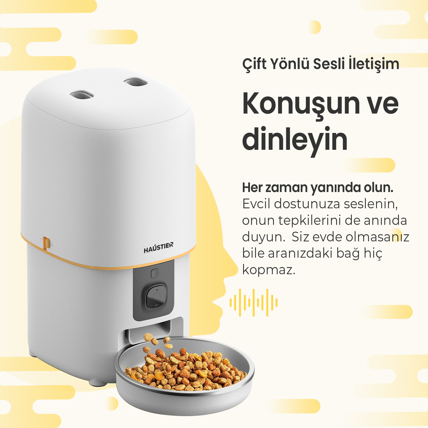 Beyaz bir evcil hayvan besleyici, bir kaseye mama dağıtıyor. Metin şöyle diyor: 'Konuş ve dinle'. Marka adı 'HAUSTIER'.