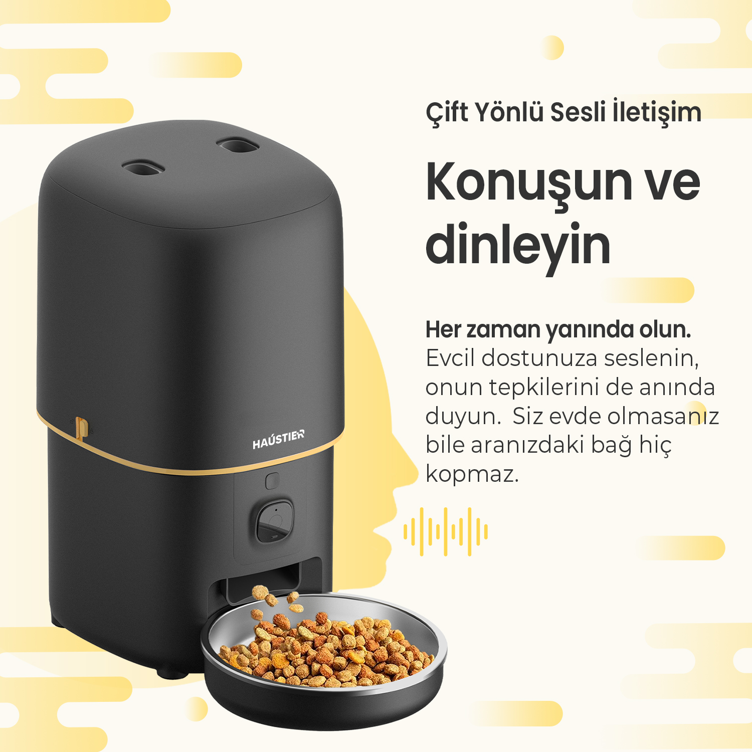 Siyah evcil hayvan maması dağıtıcısı, metal bir kapta mama ile. Metin, çift yönlü sesli iletişimi teşvik ediyor.