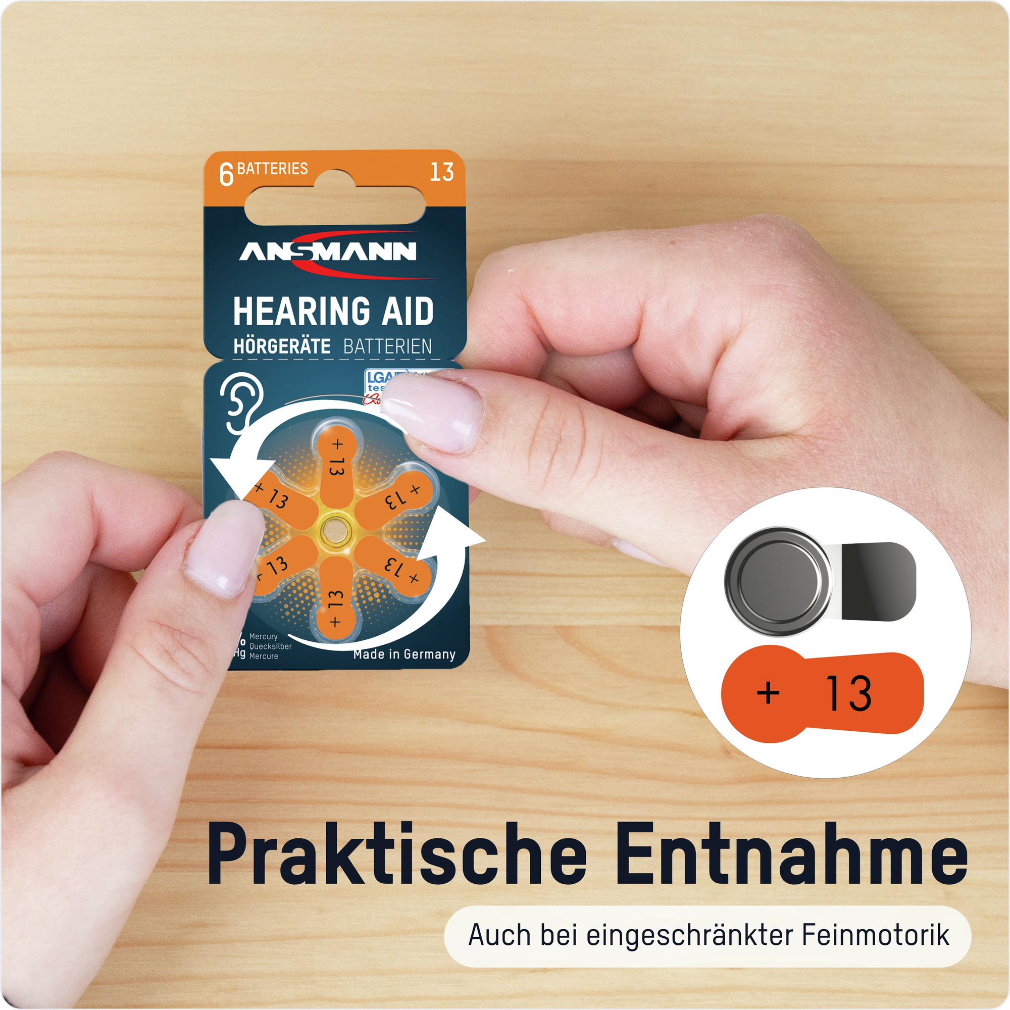Eine Hand hält eine Hörgerätebatteriepackung. Die Packung zeigt Batterien mit einem weißen Pfeil. Der Hintergrund ist aus Holz.
