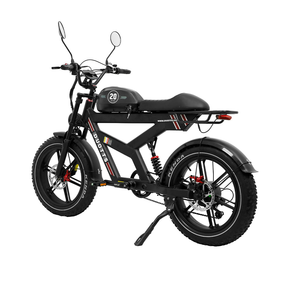 Bicicletta elettrica nera con pneumatici larghi. Ha sella, manubrio e telaio neri. Il marchio 'DUOTTS' è visibile.