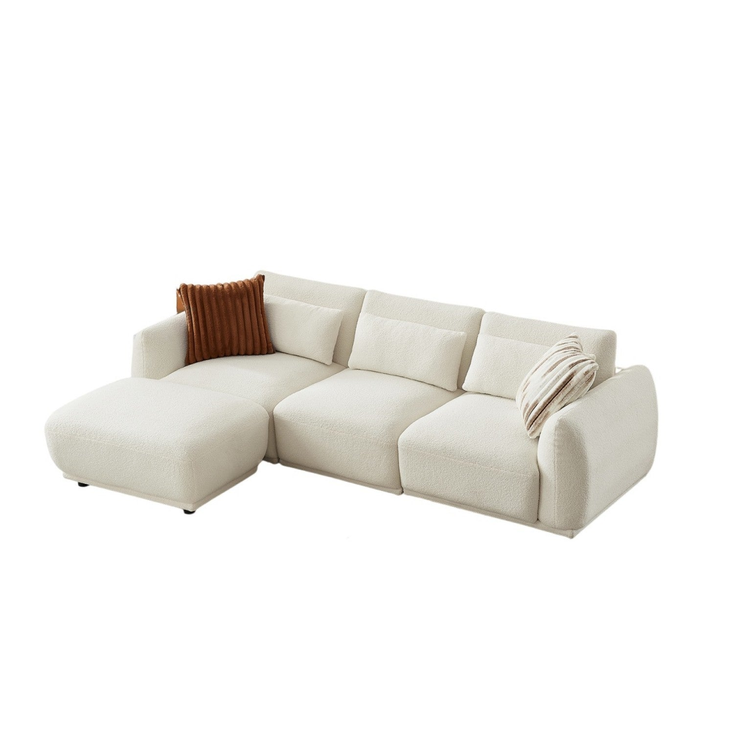 Un grande divano componibile bianco sporco con chaise longue. Ha diversi cuscini nei toni del marrone e beige.
