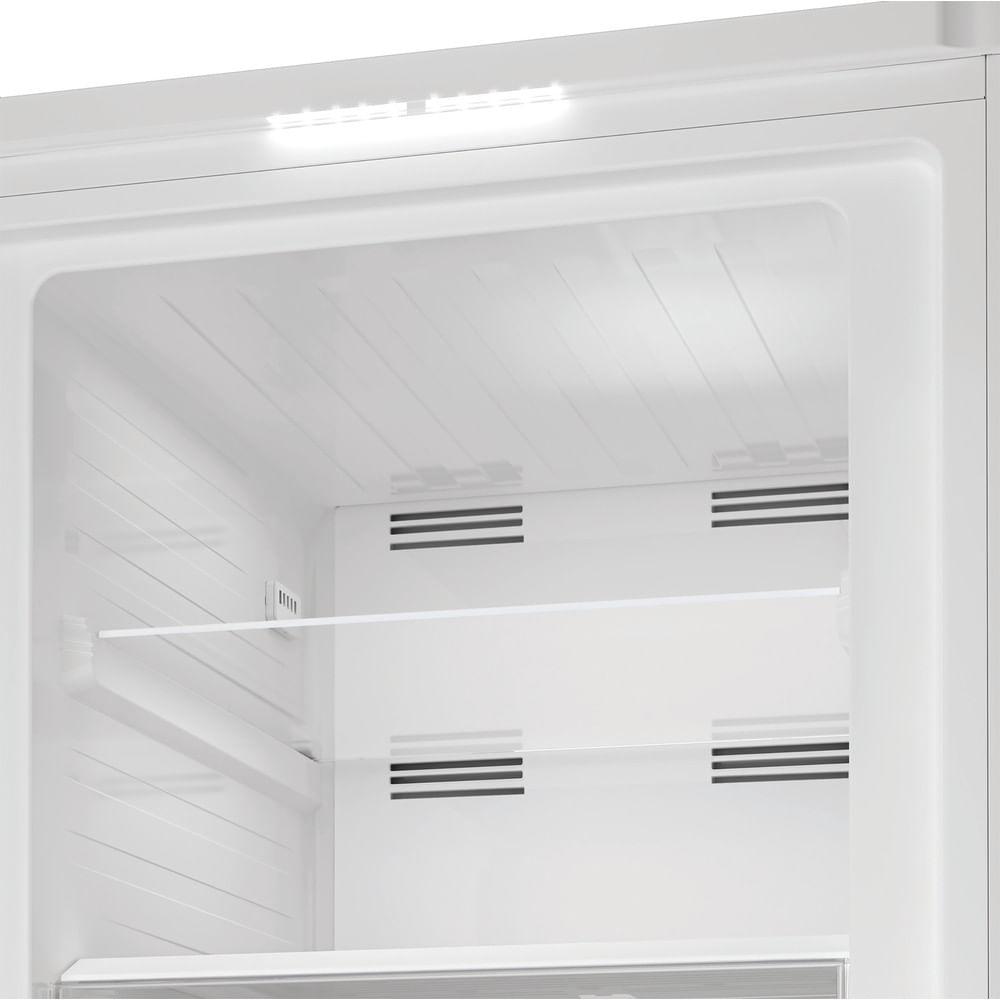 Interieur van een witte koelkast, verlicht door een lichtstrip. Er zijn planken en ventilatieopeningen. Het ontwerp is strak en minimalistisch.