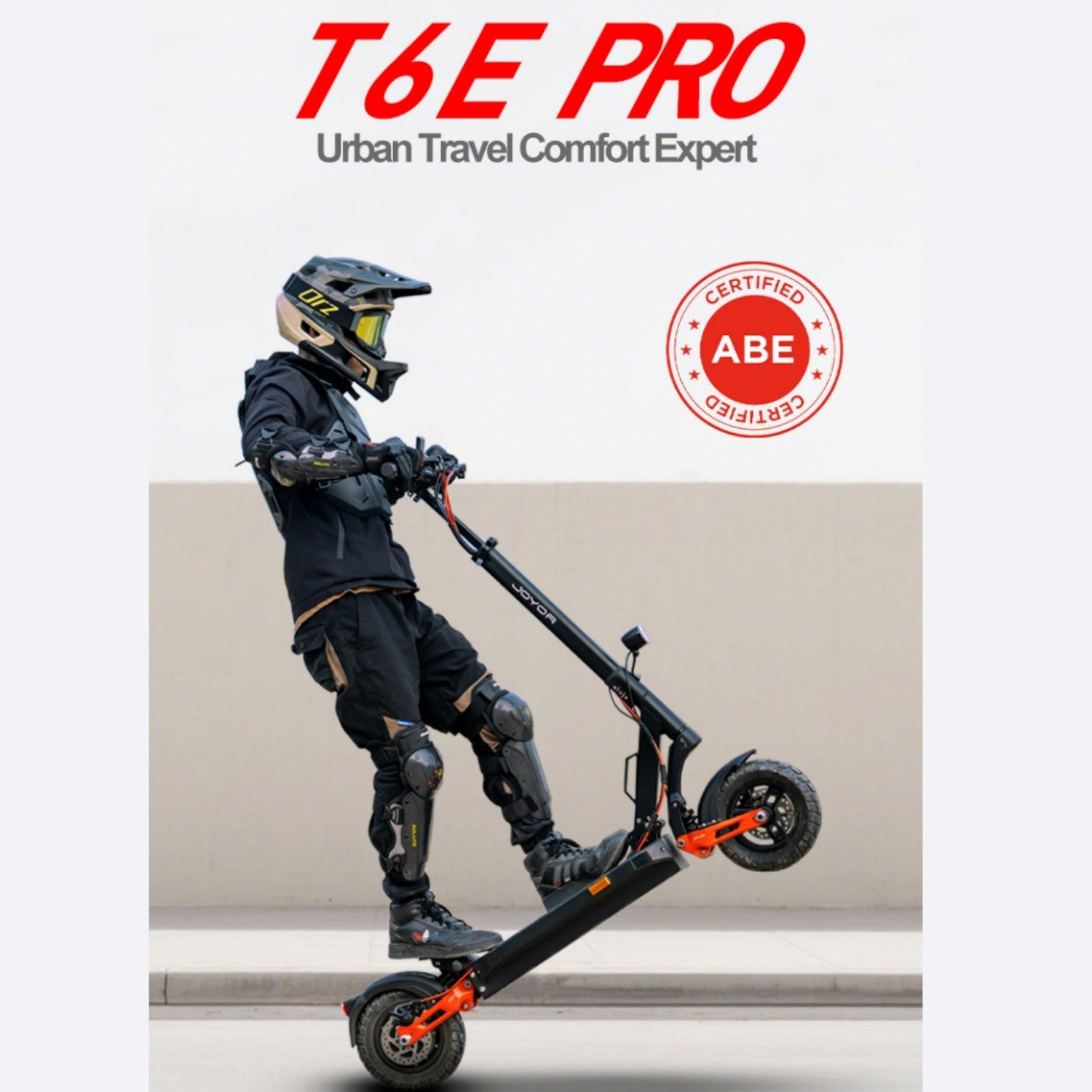 Una persona con il casco guida un monopattino elettrico nero e arancione. Lo scooter è inclinato. Lo sfondo è un muro liscio.