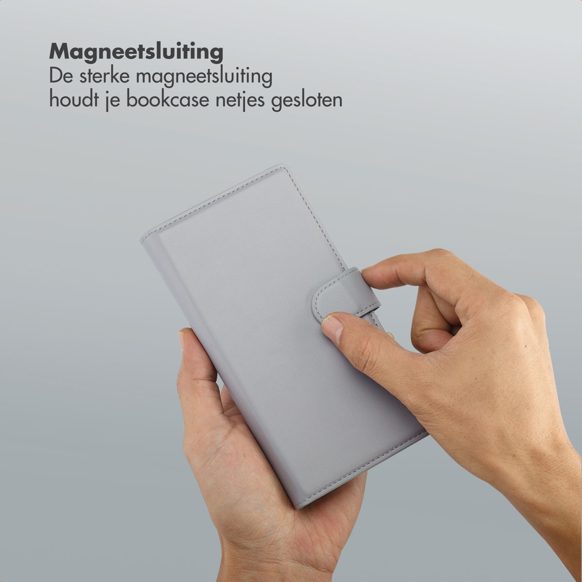 Une main tient un étui de téléphone gris avec une fermeture magnétique. La main ferme l'étui. Texte dans le coin supérieur gauche.