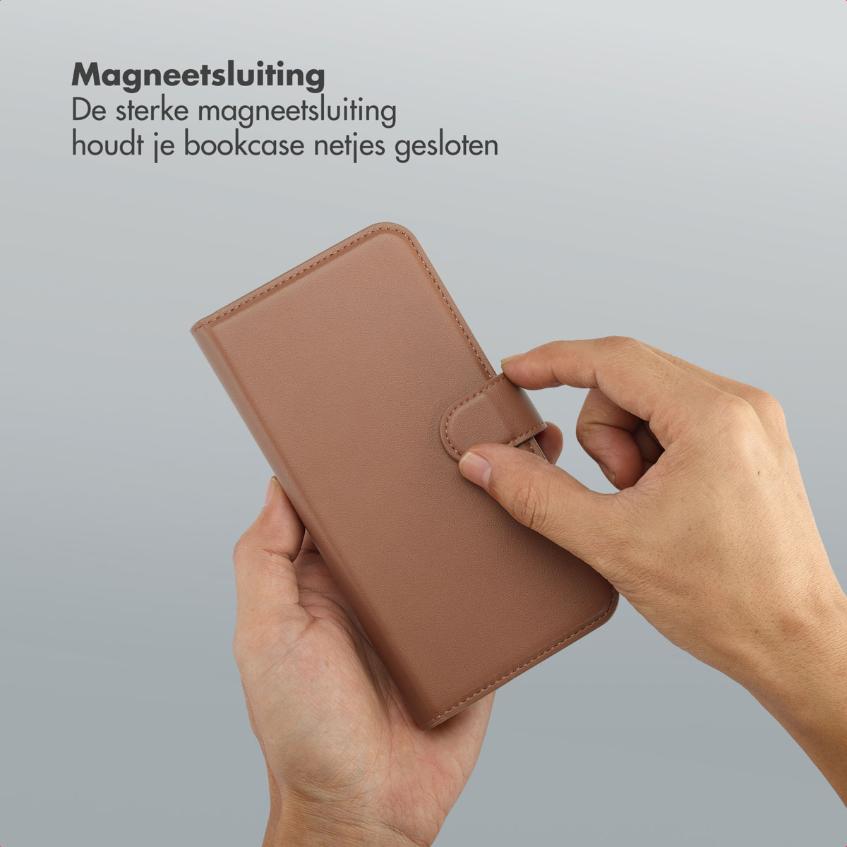 Mains tenant un étui de téléphone marron. L'étui a une fermeture magnétique, la main le ferme.