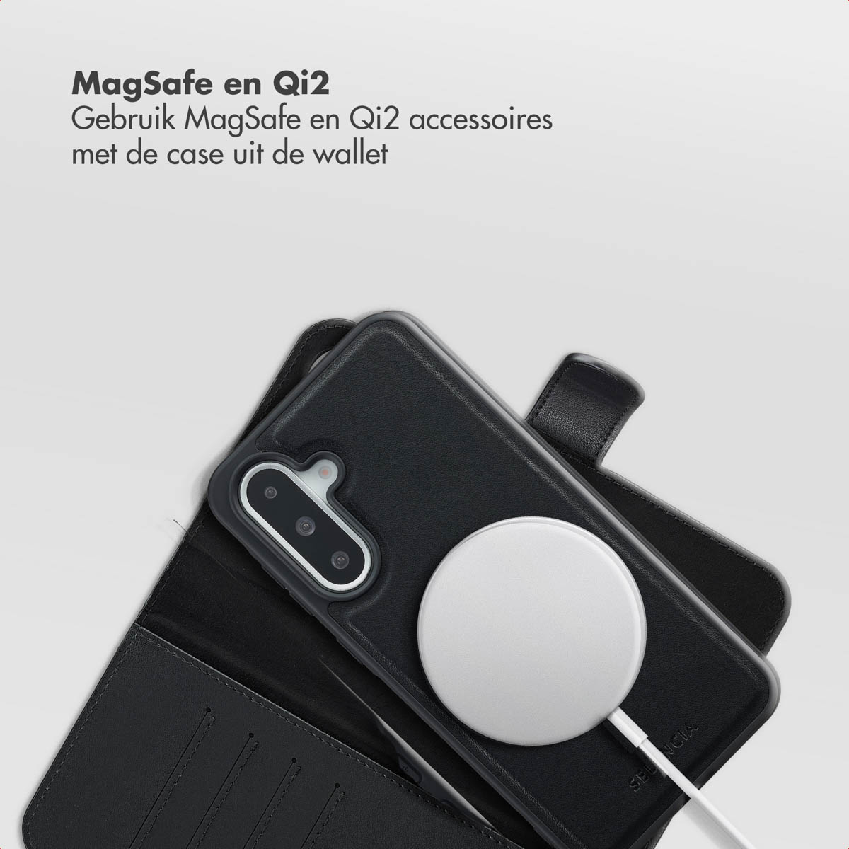 Un téléphone noir dans un étui portefeuille avec un chargeur blanc attaché. Le texte en haut indique MagSafe et Qi2.
