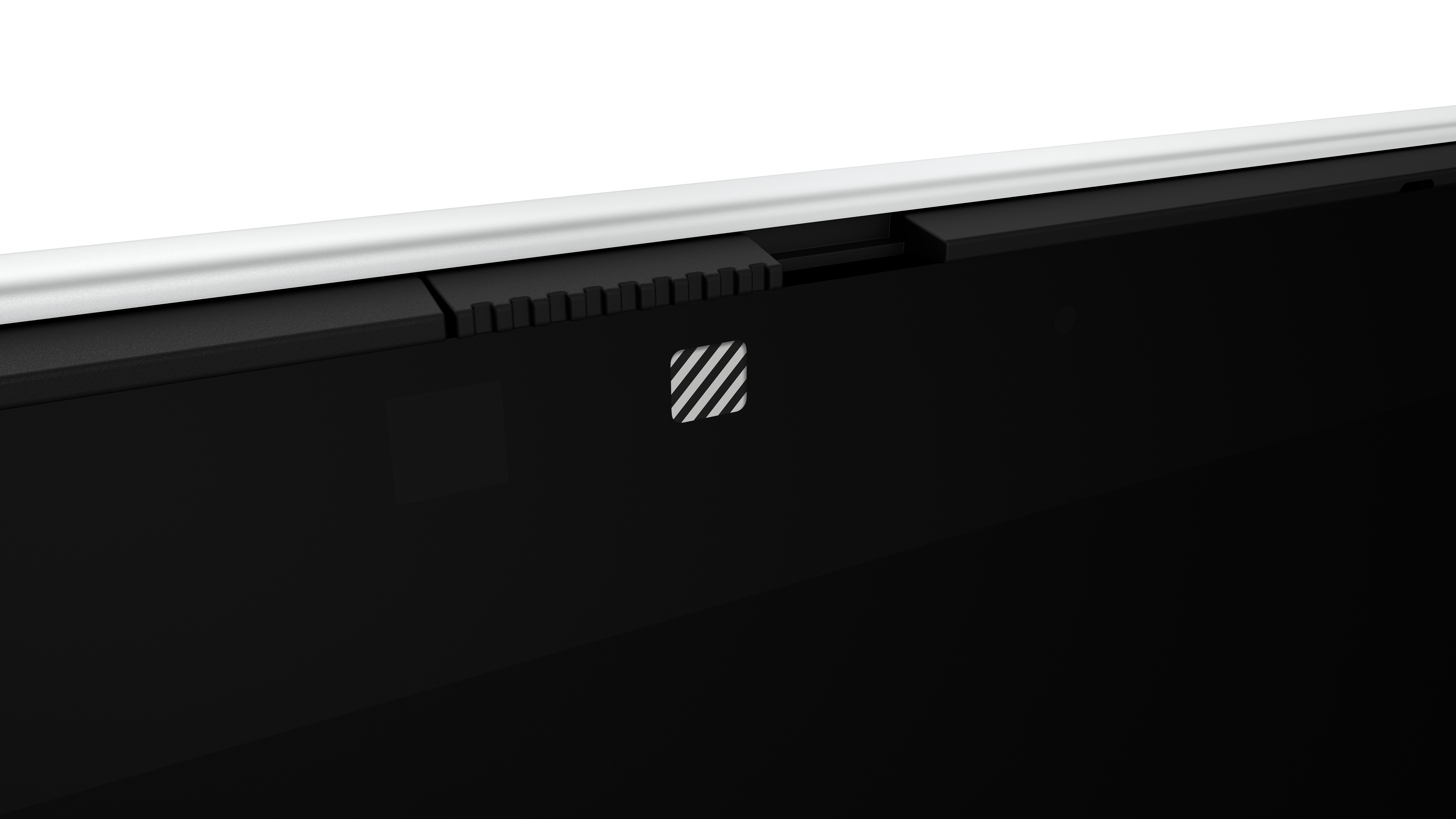 Close-up of a device. Black surface with a white logo. Silver edge on top, black hinge-like feature. White background.
