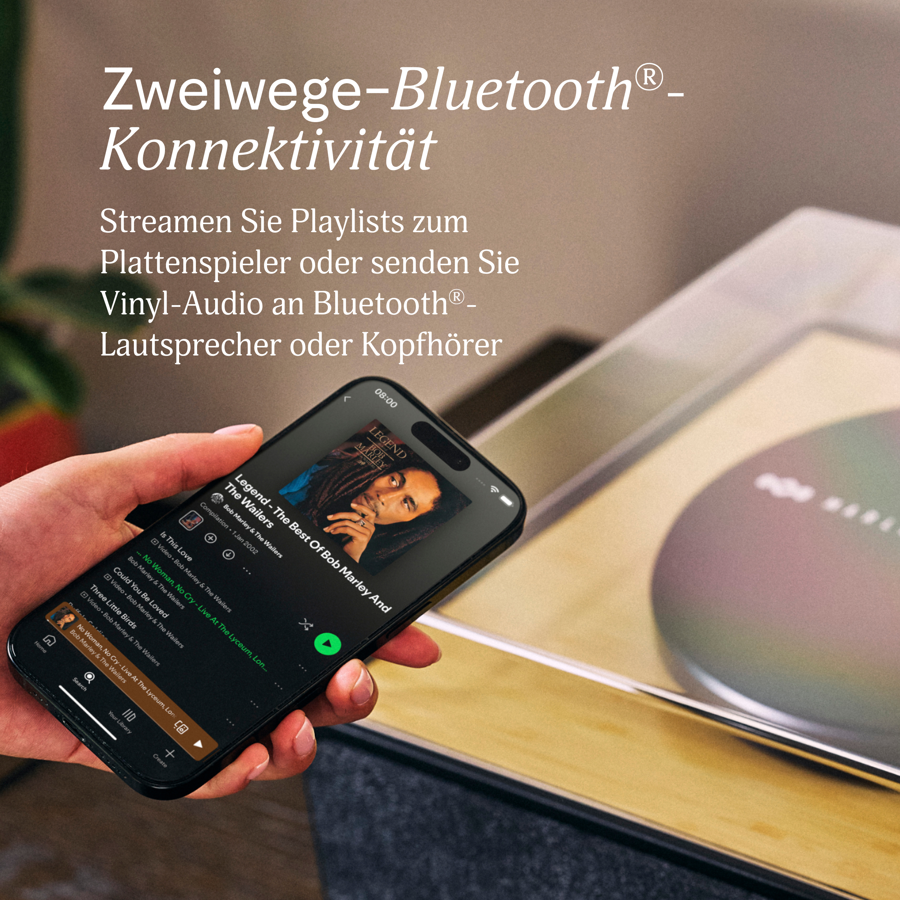Une main tient un téléphone affichant un album de Bob Marley sur Spotify. Texte superposé faisant la promotion de la connectivité Bluetooth.