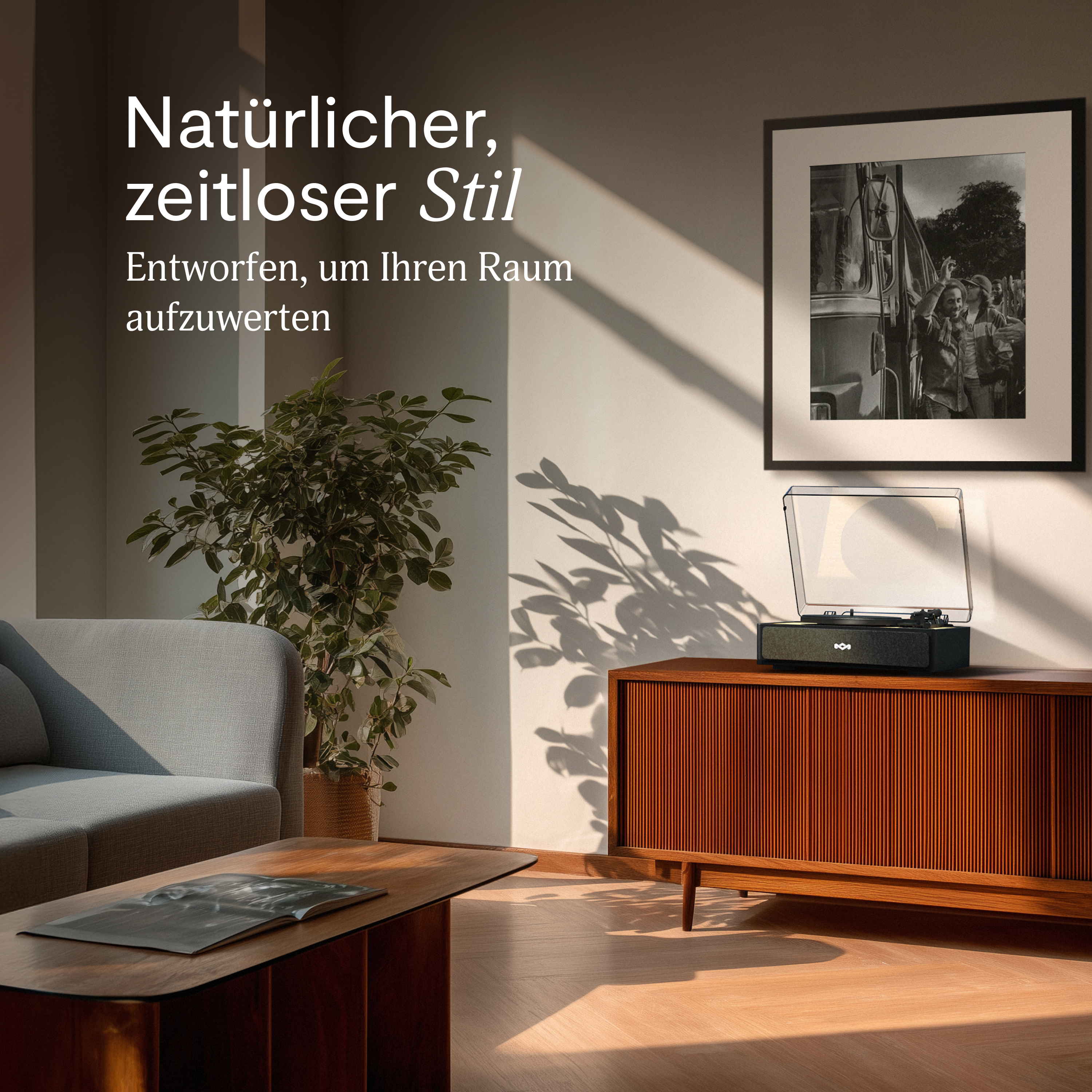 Un salon avec une platine sur une armoire en bois. Un tableau encadré est accroché au mur et un canapé et une plante sont dans la pièce.