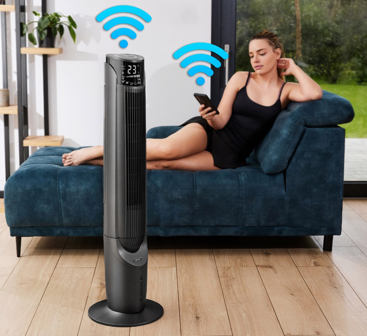 Kobieta na niebieskiej sofie używa telefonu. Obok stoi czarny wentylator wieżowy. Symbole Wi-Fi unoszą się nad. Pokój ma drewniane podłogi.