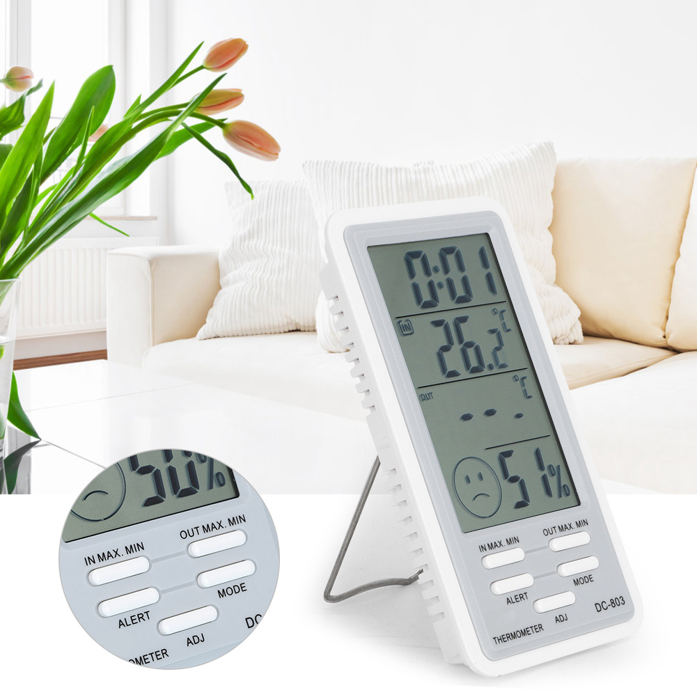 Ein digitales Thermometer zeigt Temperatur- und Feuchtigkeitswerte an. Ein kleiner, abgetrennter Kreis zeigt ein trauriges Gesicht mit 50 % Luftfeuchtigkeit.