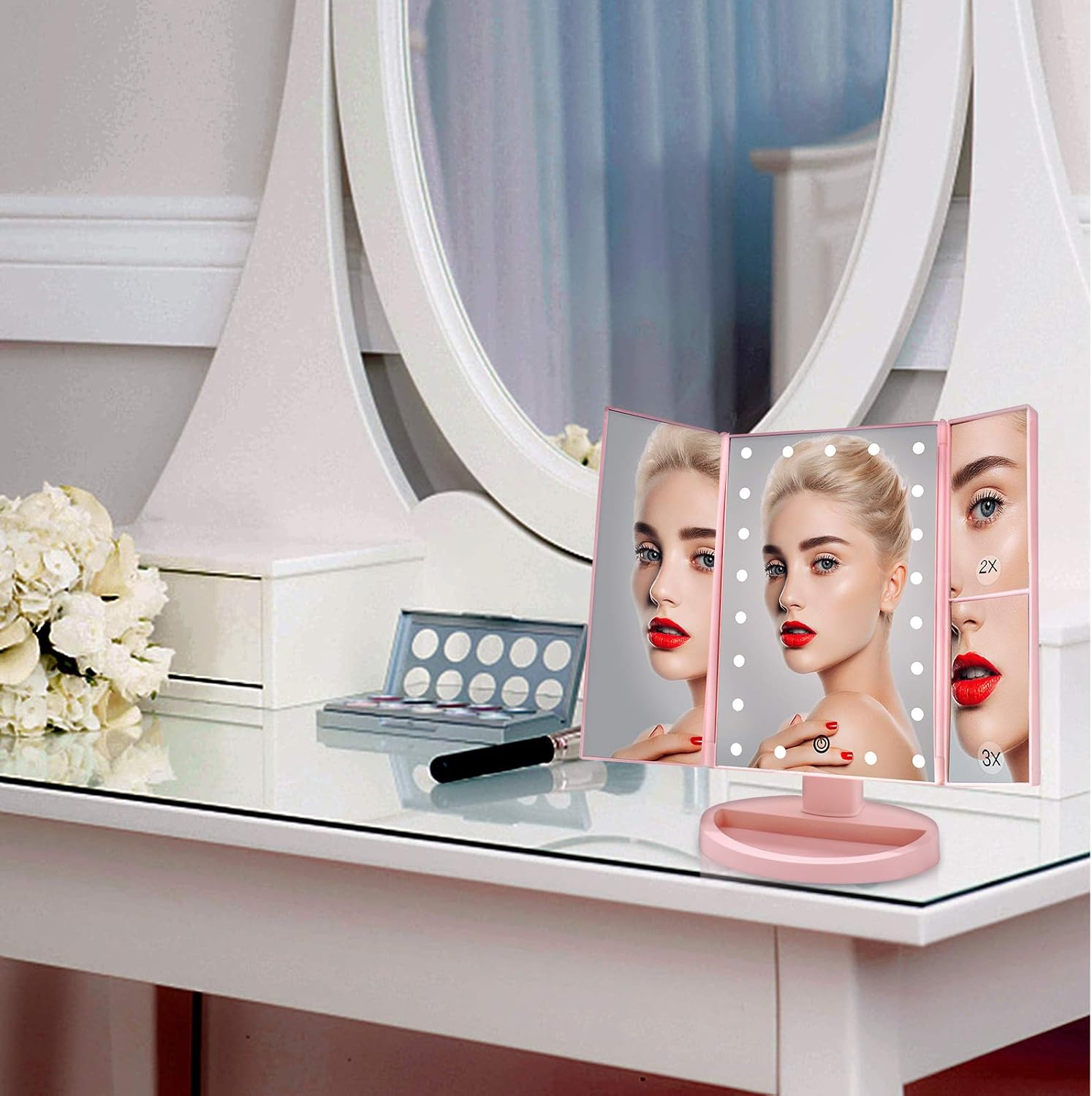 Ein Schminktisch mit einem Spiegel, der das Gesicht einer Frau, eine Make-up-Palette und Blumen widerspiegelt.