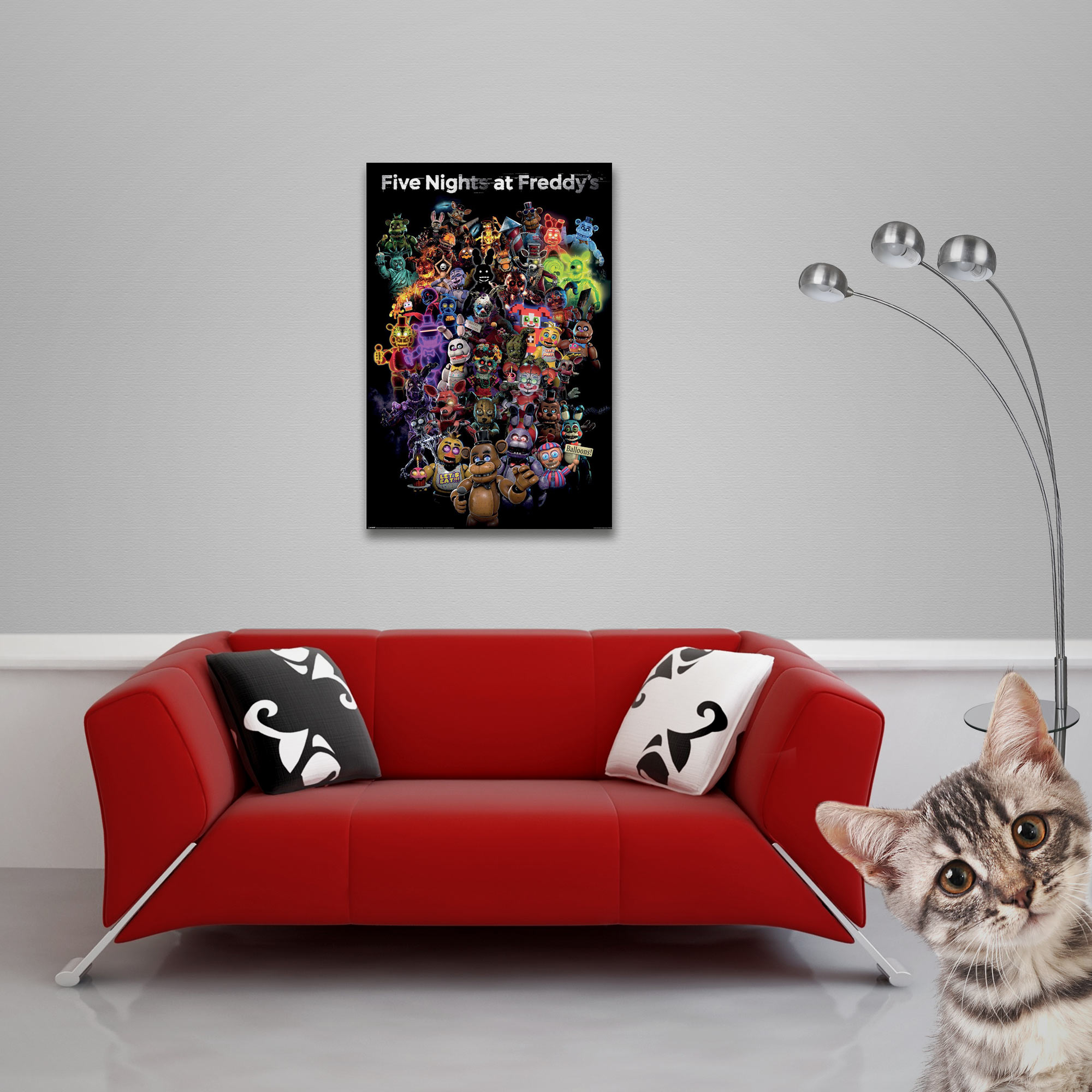 Rotes Sofa mit Kissen, Poster, Lampe und Katze, die in die Kamera schaut.