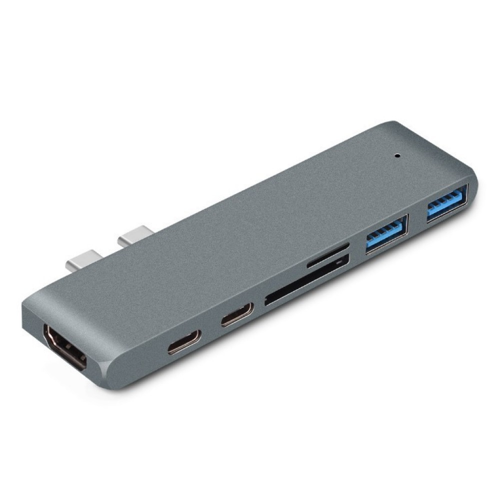 Ein grauer USB-C-Hub mit mehreren Anschlüssen, darunter HDMI, USB und ein SD-Kartenleser. Er befindet sich auf weißem Hintergrund.