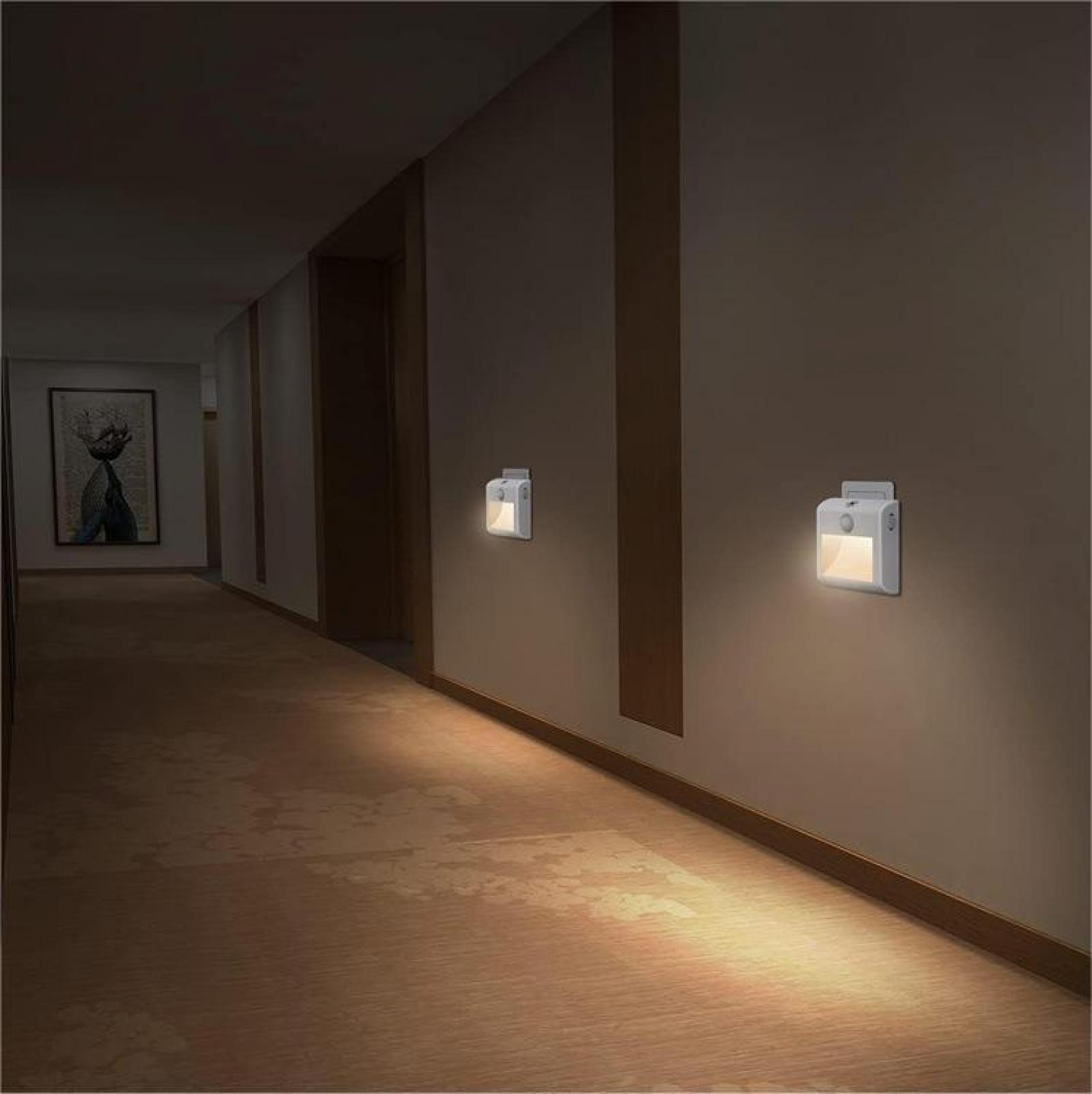 Ein Flur mit Wandleuchten. Ein Gemälde hängt an der Wand. Der Boden ist mit Teppich ausgelegt.