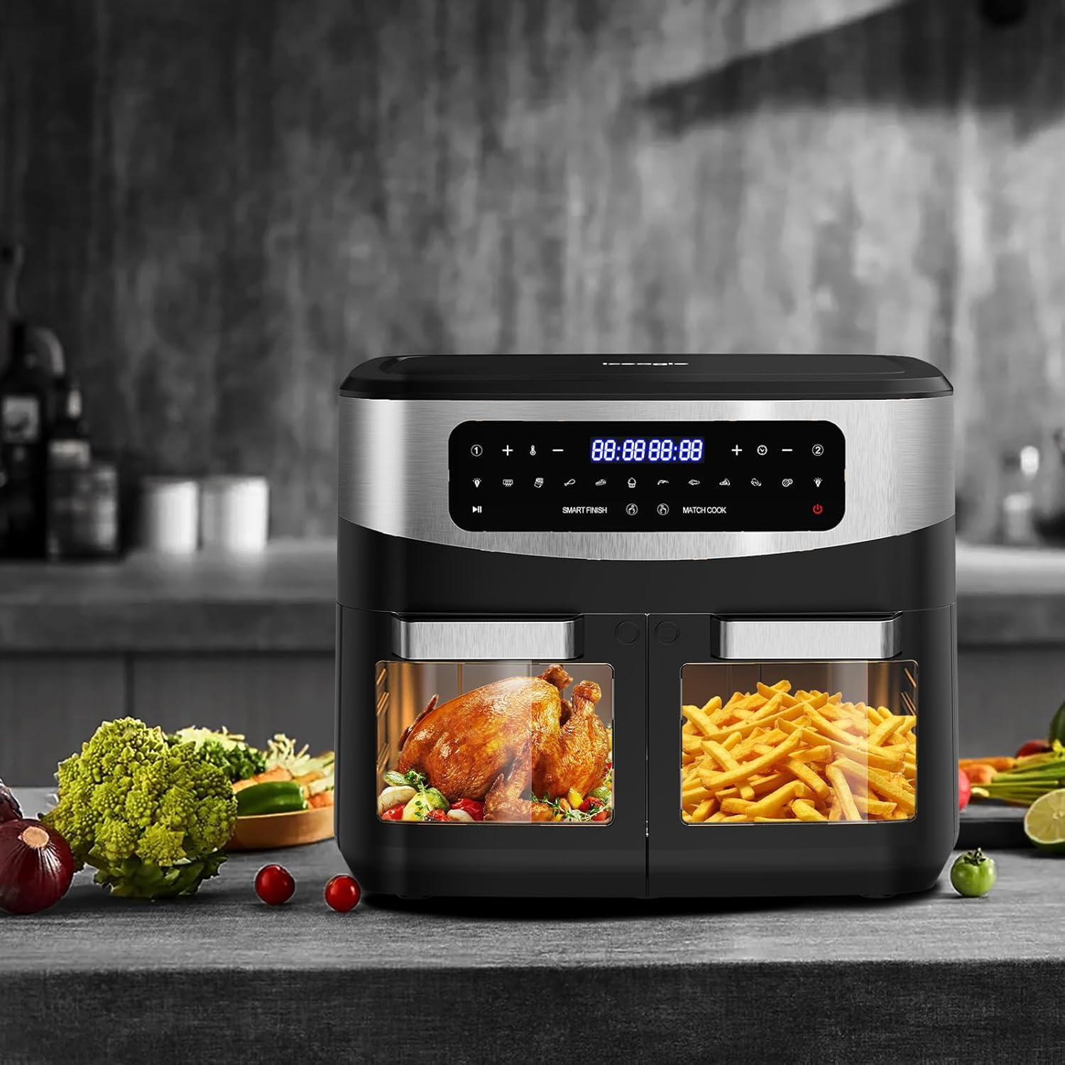 Eine Heißluftfritteuse mit Hähnchen und Pommes Frites. Gemüse liegt auf der Theke. Die Fritteuse hat ein digitales Display.