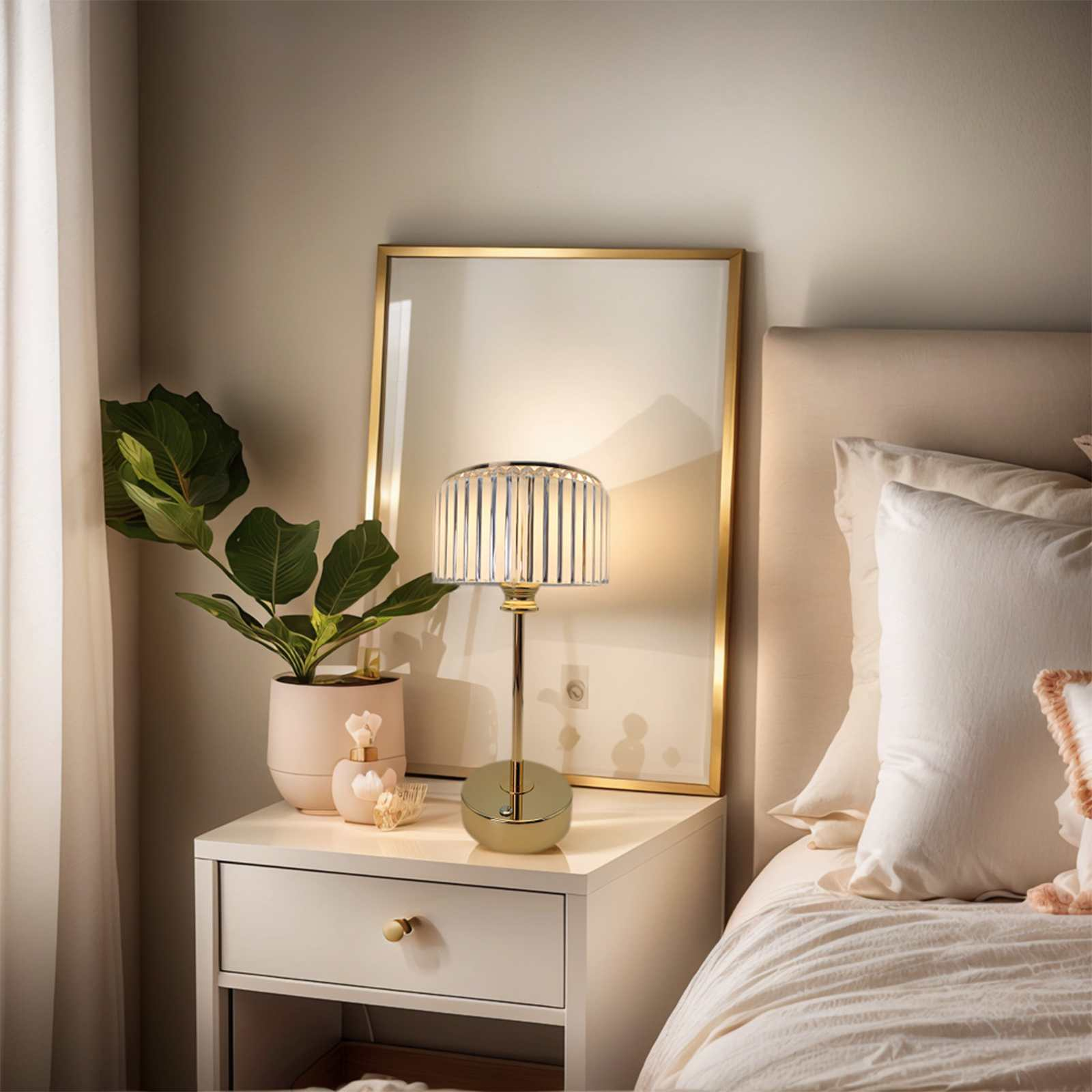 Eine Szene am Bett mit Lampe, Pflanze und Spiegel. Ein weißer Nachttisch mit goldener Lampe und einem Blumentopf neben einem Bett.