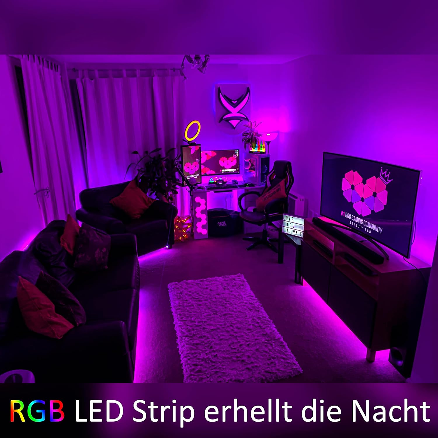 Ein Raum mit violetten RGB-LED-Streifen beleuchtet. Es gibt ein Gaming-Setup, ein Sofa mit Kissen und einen Fernseher.