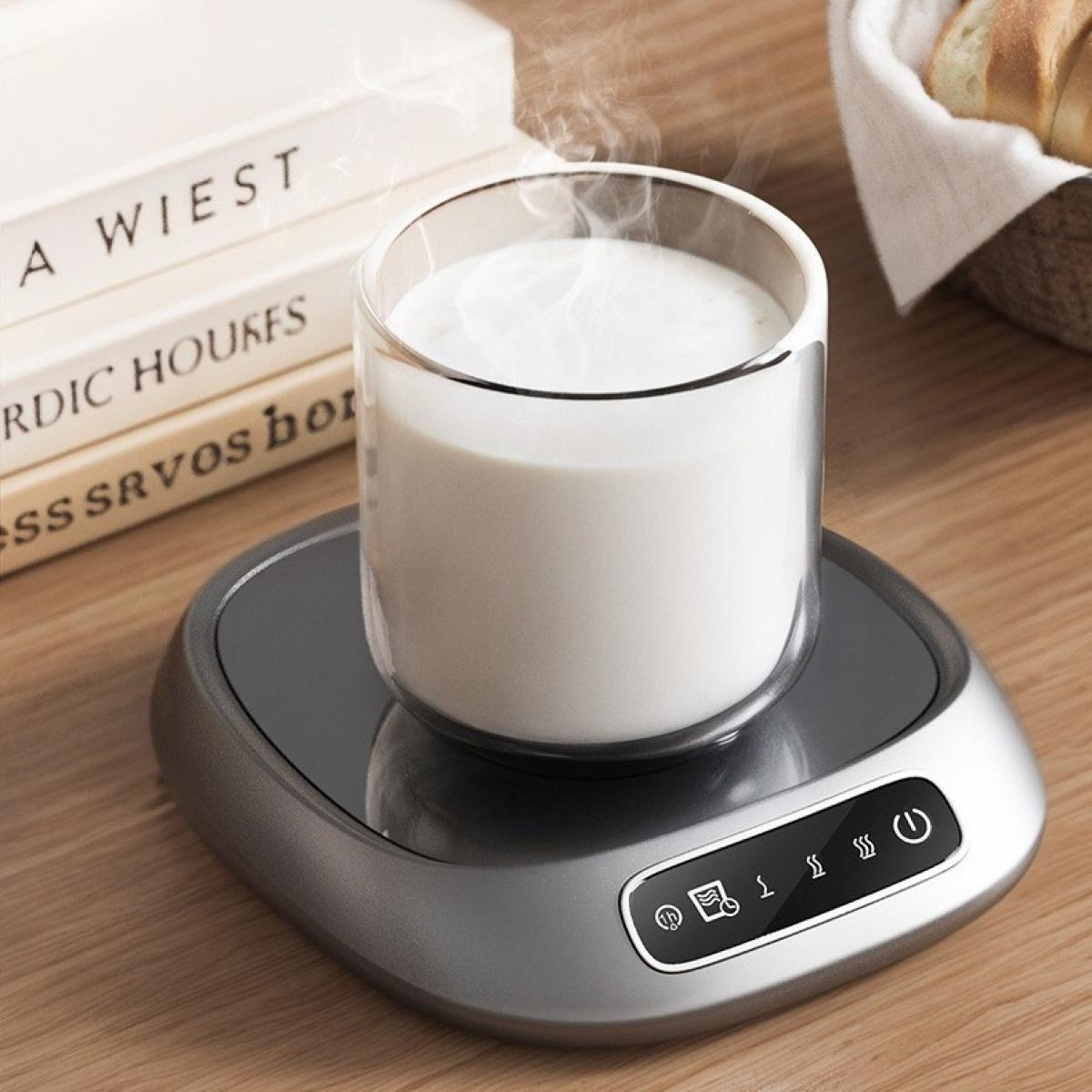 Ein Glas Milch steht auf einem Wärmer, Dampf steigt auf. Bücher und Brot in einem Korb stehen auf dem Holztisch.