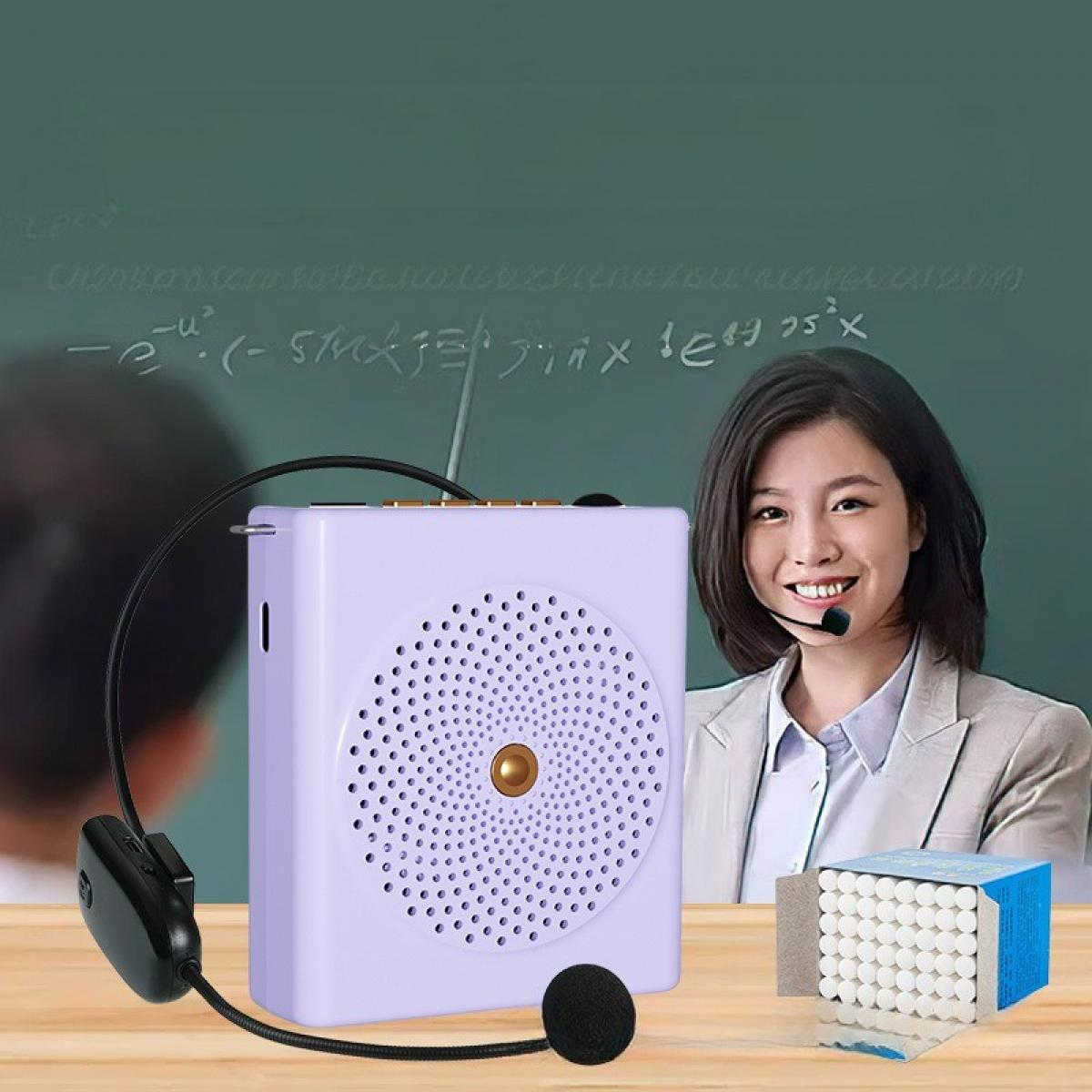 Eine Frau mit Headset-Mikrofon lächelt neben einem lila Lautsprecher. Im Hintergrund befindet sich eine Tafel mit Gleichungen.