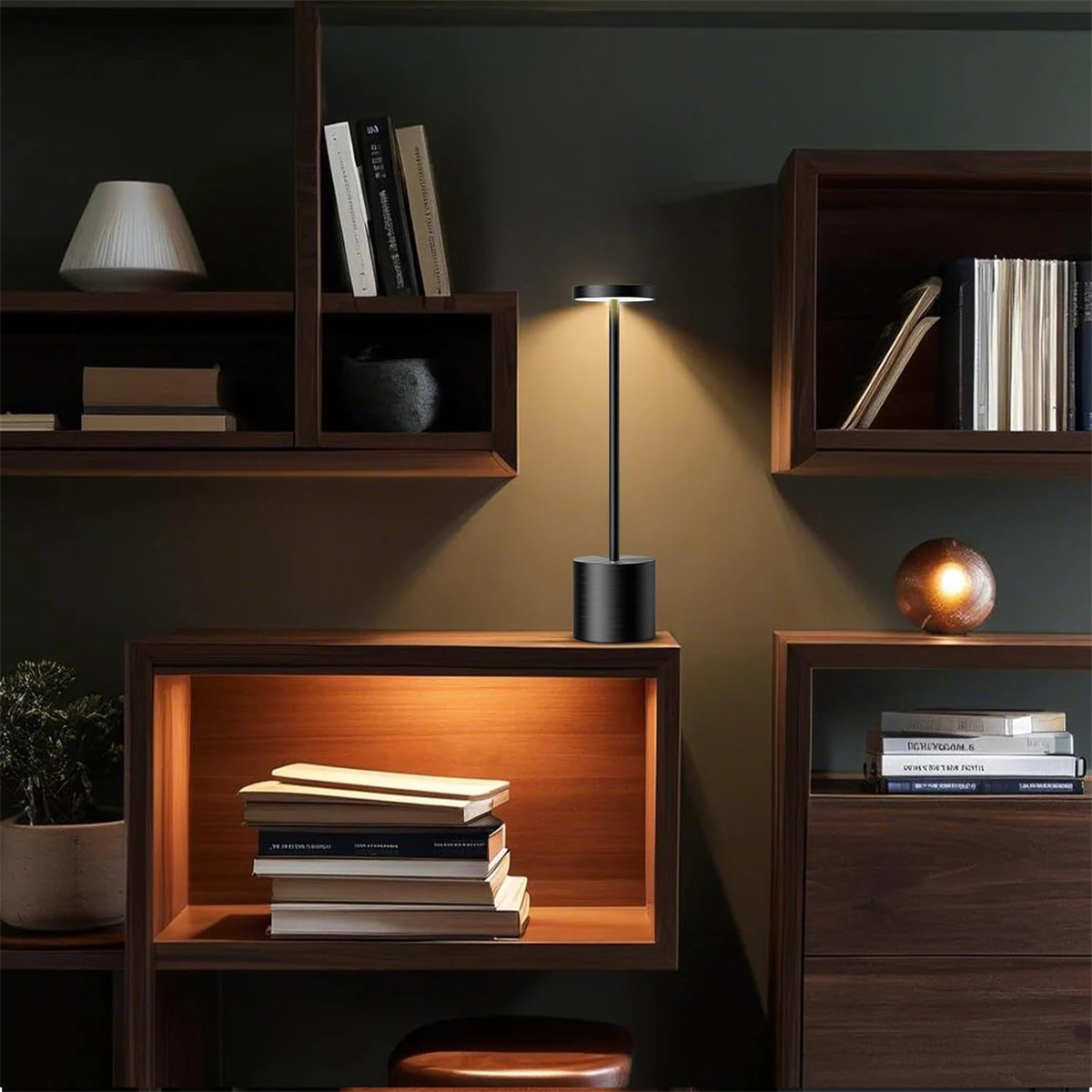 Eine schwarze Lampe beleuchtet ein Regal. Bücher und Dekorationsartikel stehen auf Holzregalen. Ein warmes Licht leuchtet in den Regalen.