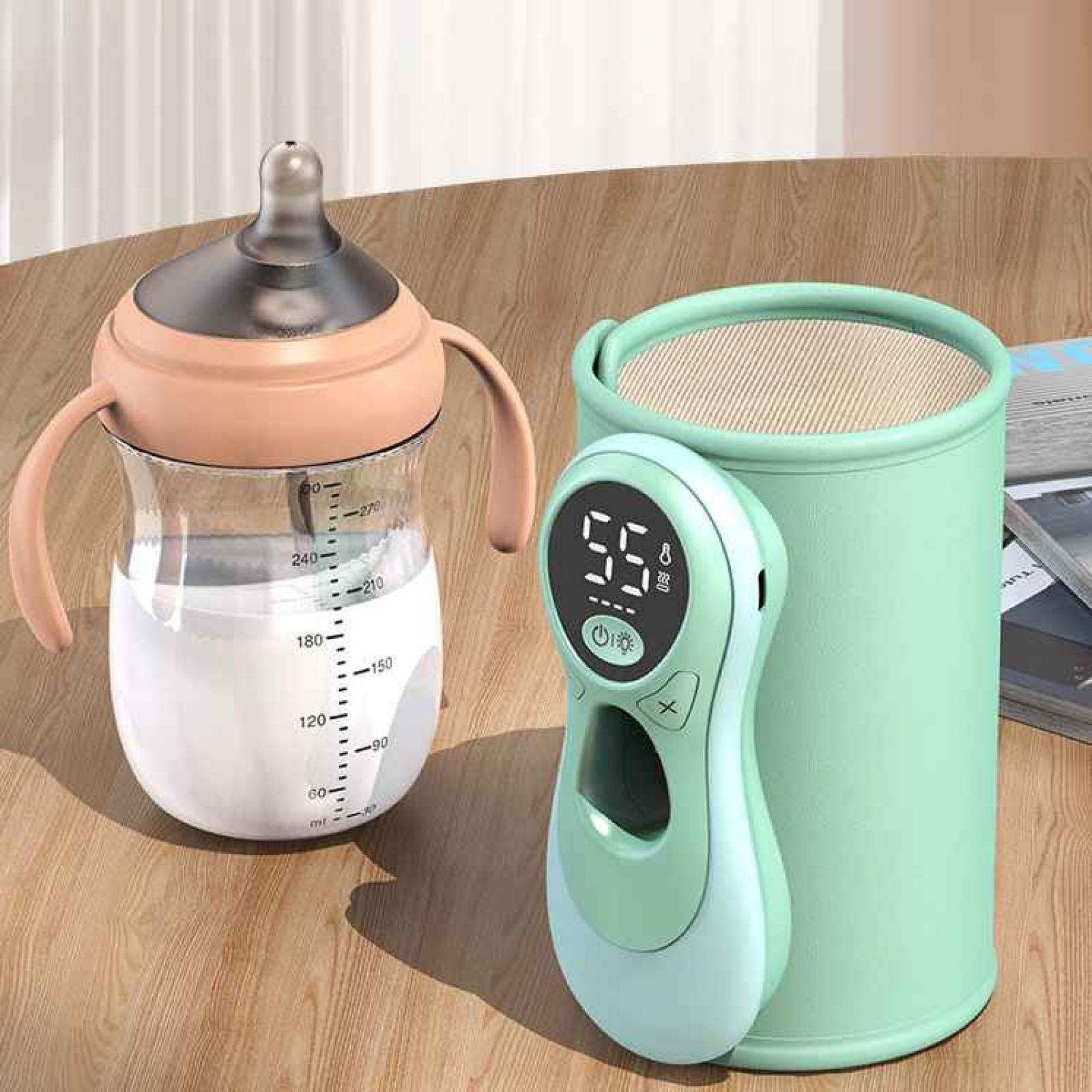 Eine Babyflasche mit Milch, ein grüner Wärmer und eine digitale Anzeige stehen auf einer Holzoberfläche.
