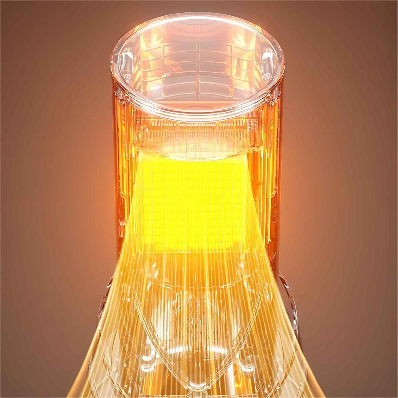 Nahaufnahme eines transparenten Geräts mit hellem gelben Kern, das Licht nach unten abstrahlt. Der Hintergrund ist braun.