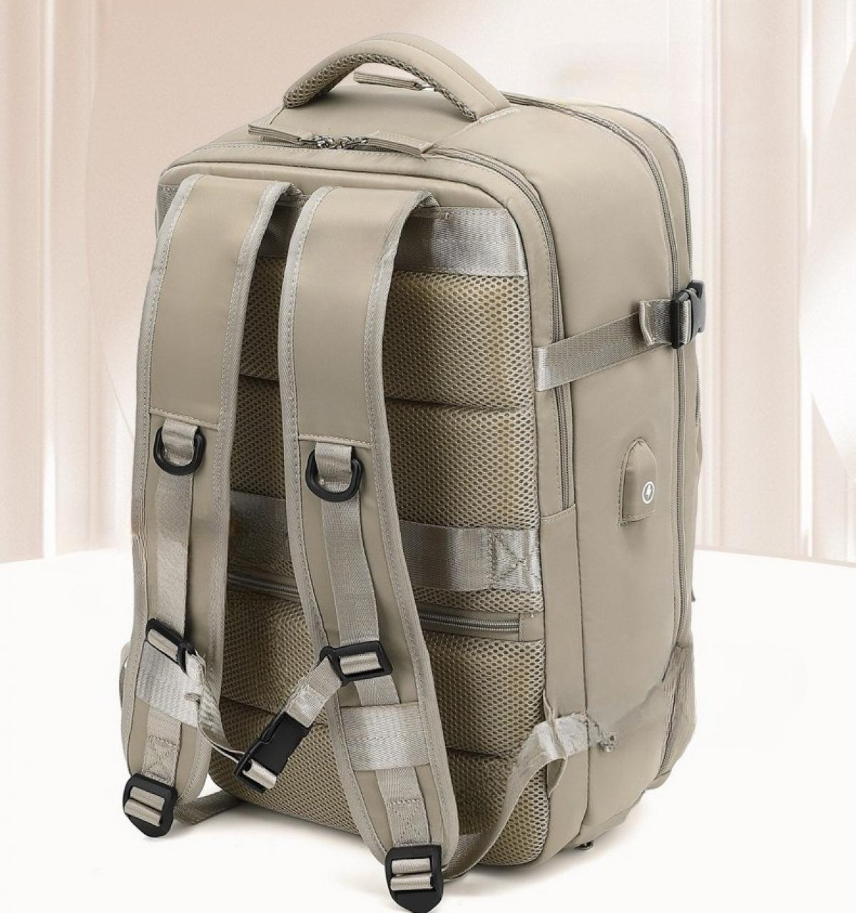 Ein beiger Rucksack mit mehreren Riemen und Schnallen, einem Griff oben, Mesh-Rückenlehne und einem Reißverschluss.