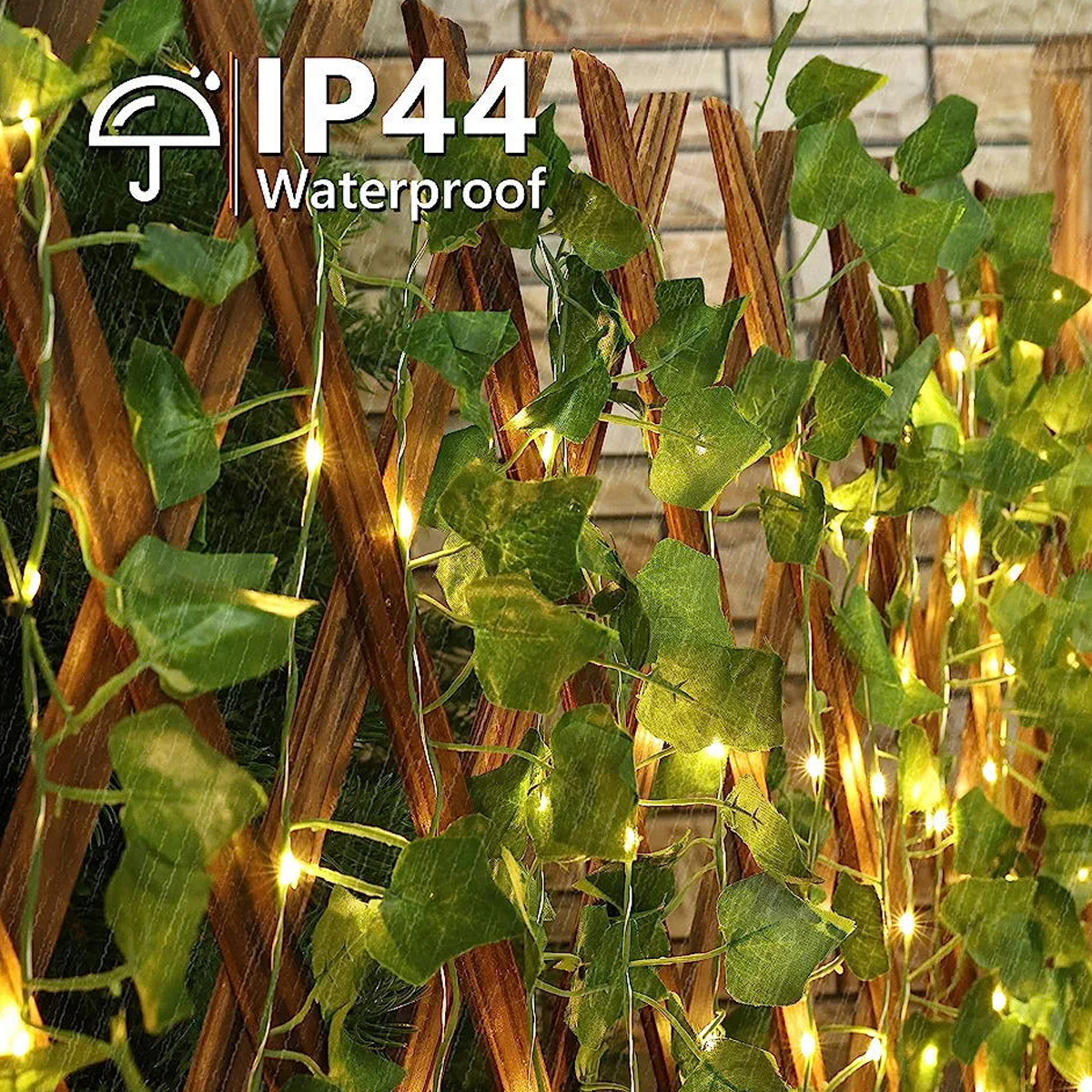 Efeu mit Lichterketten auf einem Holzgitter. Der Text 'IP44 Waterproof' ist sichtbar. Regeneffekt.