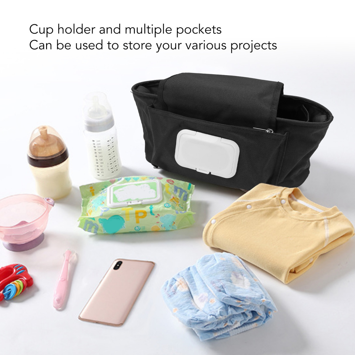Eine schwarze Baby-Organizer-Tasche mit Taschen, Flaschen, Tüchern, Kleidung, einem Telefon und Spielzeug auf einer weißen Oberfläche.
