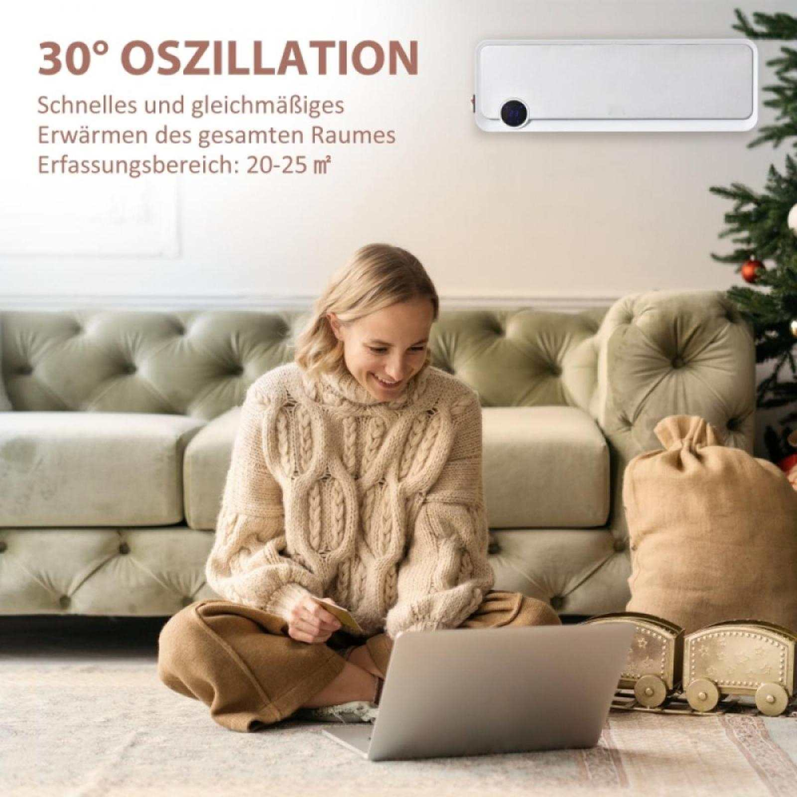 Frau benutzt Laptop auf dem Boden in der Nähe von Sofa und Weihnachtsbaum. Ein Heizgerät ist an der Wand montiert.