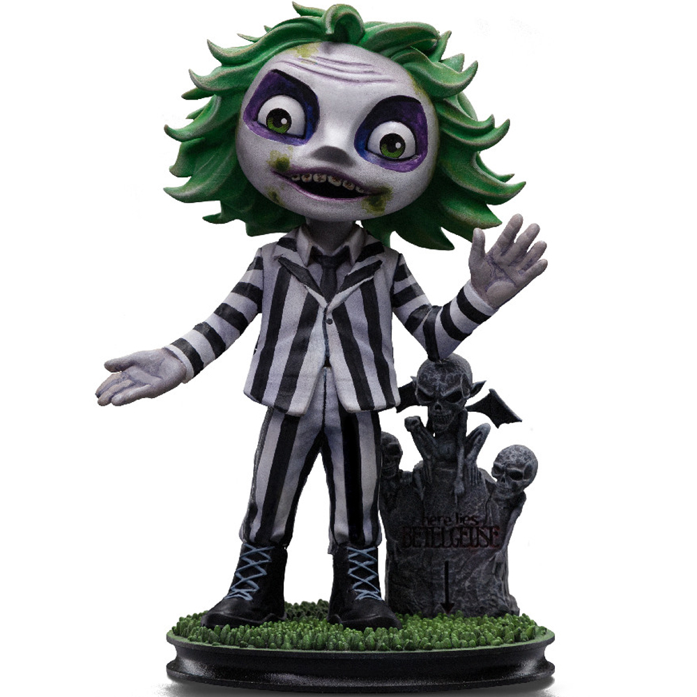 Figurina di Beetlejuice. Capelli verdi, viso bianco con trucco verde, abito a righe bianche e nere. Una lapide è dietro di lui.