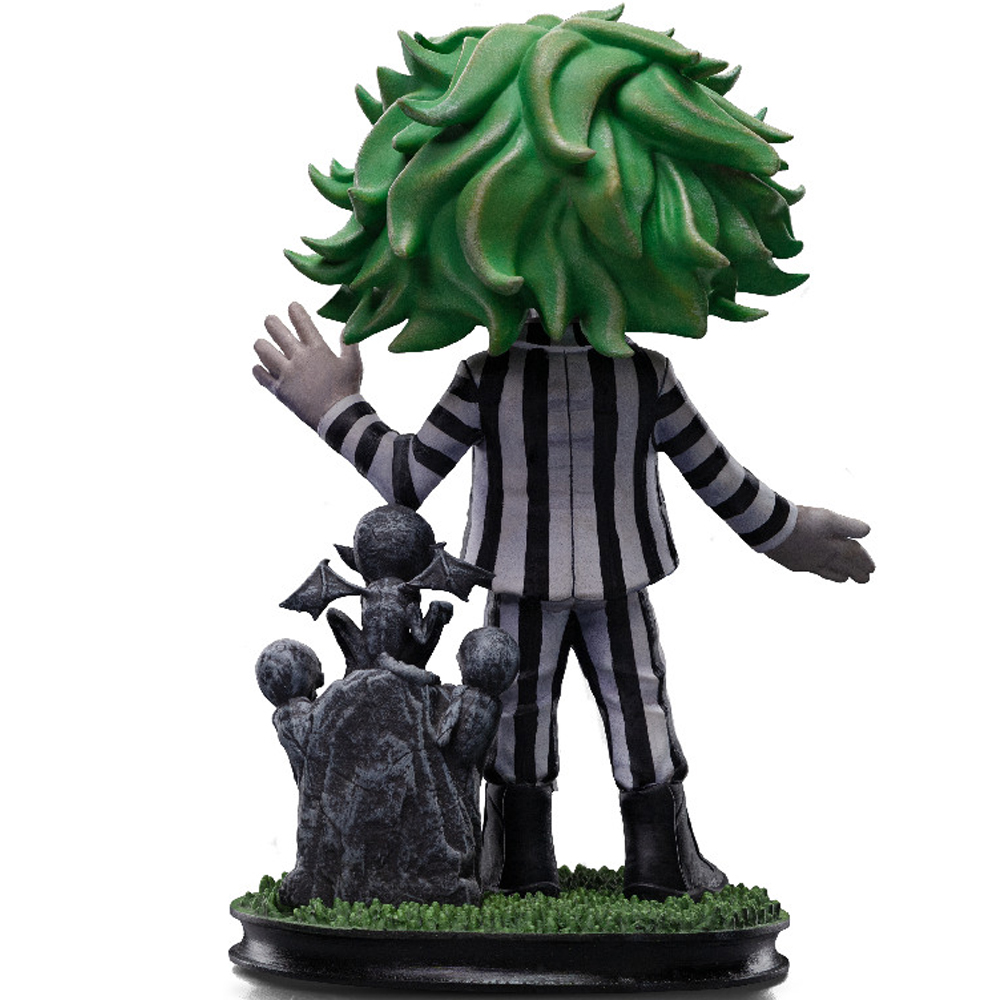 Una statuetta di Beetlejuice con testa verde a forma di capelli, tuta a righe e una piccola base cimiteriale.