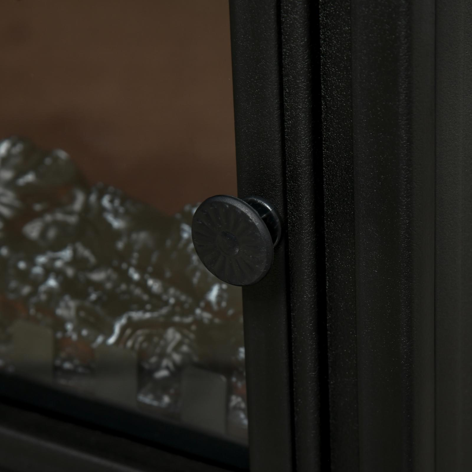 Nahaufnahme einer schwarzen Kamintür mit rundem Griff. Das Glas dahinter zeigt einen verschwommenen Feuereffekt.