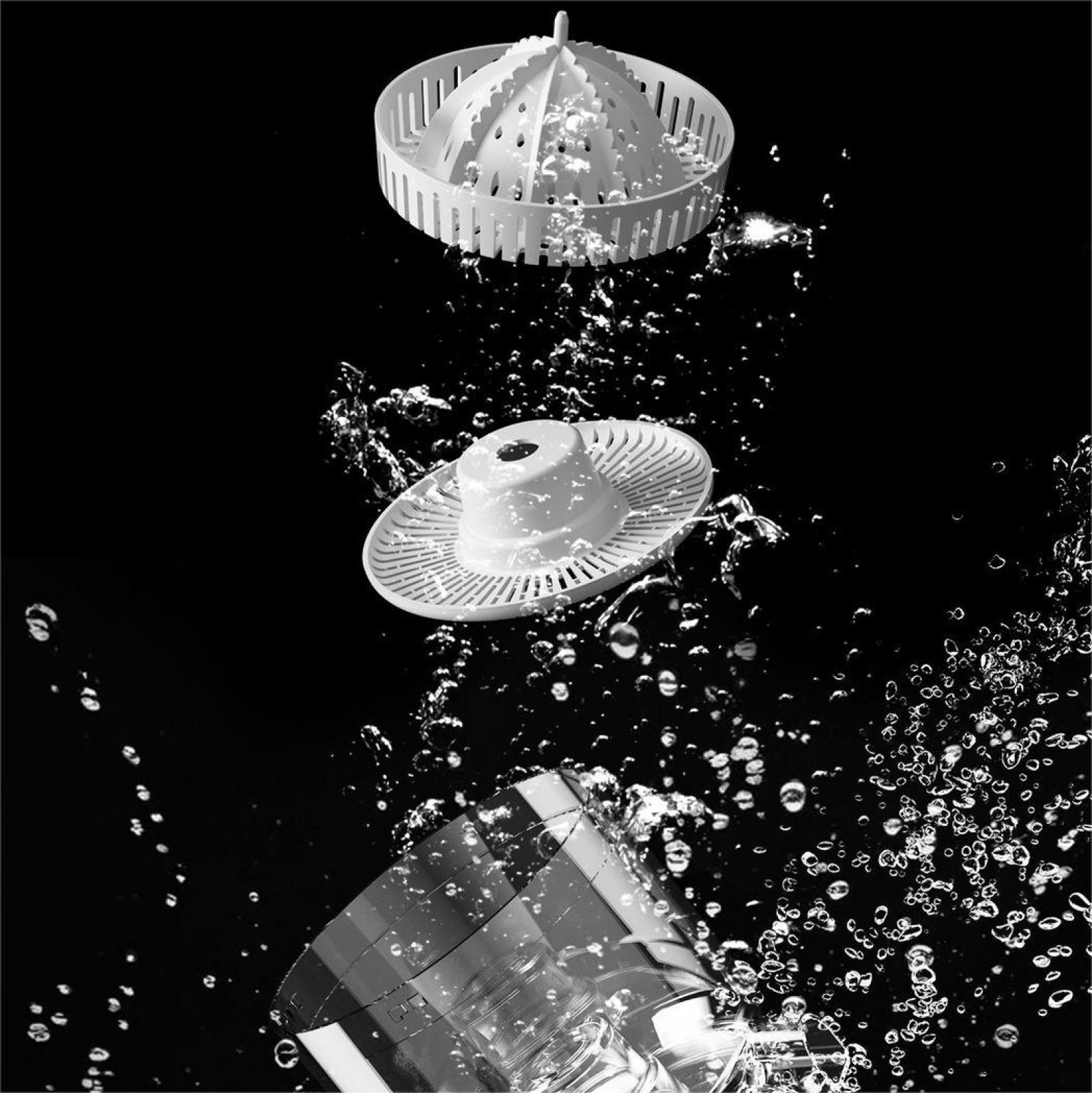 Weiße Küchengeräte Teile unter Wasser, mit Blasen vor schwarzem Hintergrund.