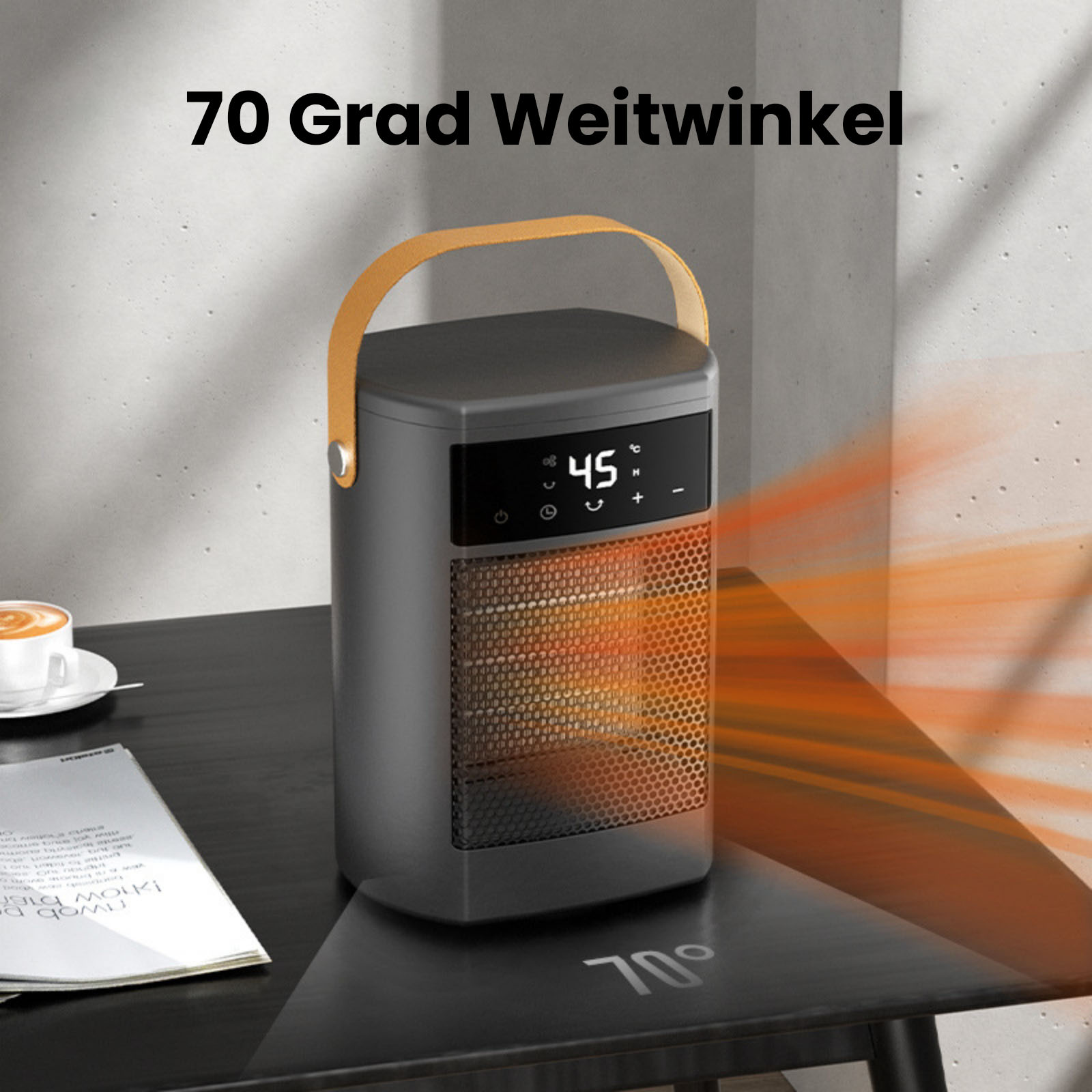 Ein grauer tragbarer Heizlüfter mit gelbem Griff auf einem schwarzen Tisch, der 45 Grad anzeigt. Eine Tasse Kaffee ist ebenfalls sichtbar.