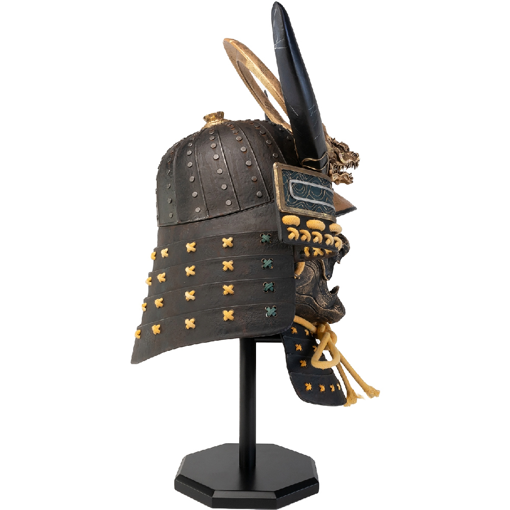 Ein schwarzer Samurai-Helm mit goldenen Akzenten, Hörnern und einem Drachendesign, ausgestellt auf einem schwarzen Ständer.