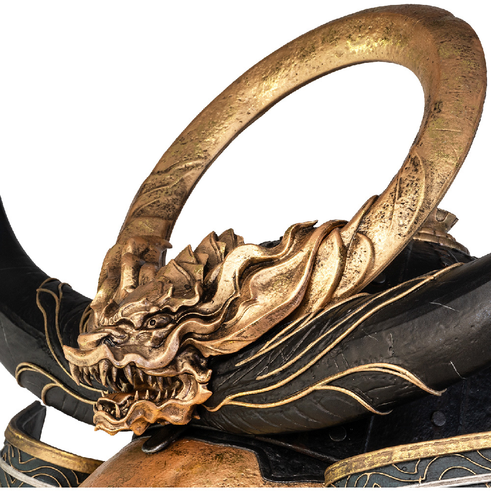 Nahaufnahme einer goldenen Drachenkopfstatue mit bogenförmigem Horn. Es hat eine schwarze Basis mit goldenen Akzenten und einem weißen Hintergrund.