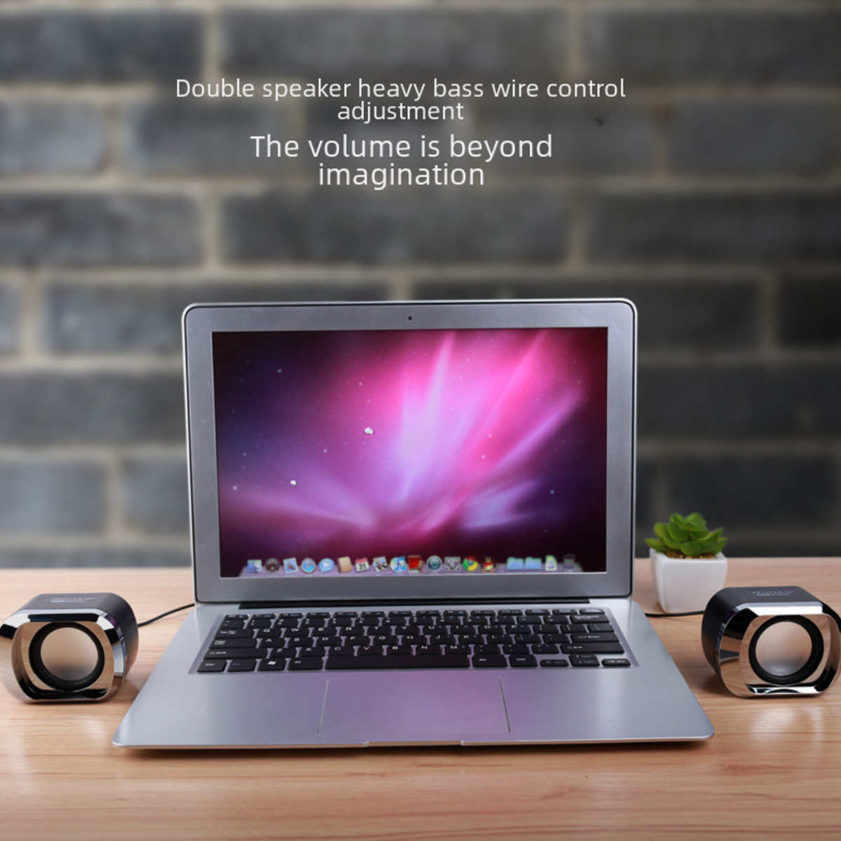 Laptop mit Lautsprechern. Ein Laptop steht auf einer Holzoberfläche. Zwei Lautsprecher befinden sich auf jeder Seite. Rechts steht eine kleine Pflanze.