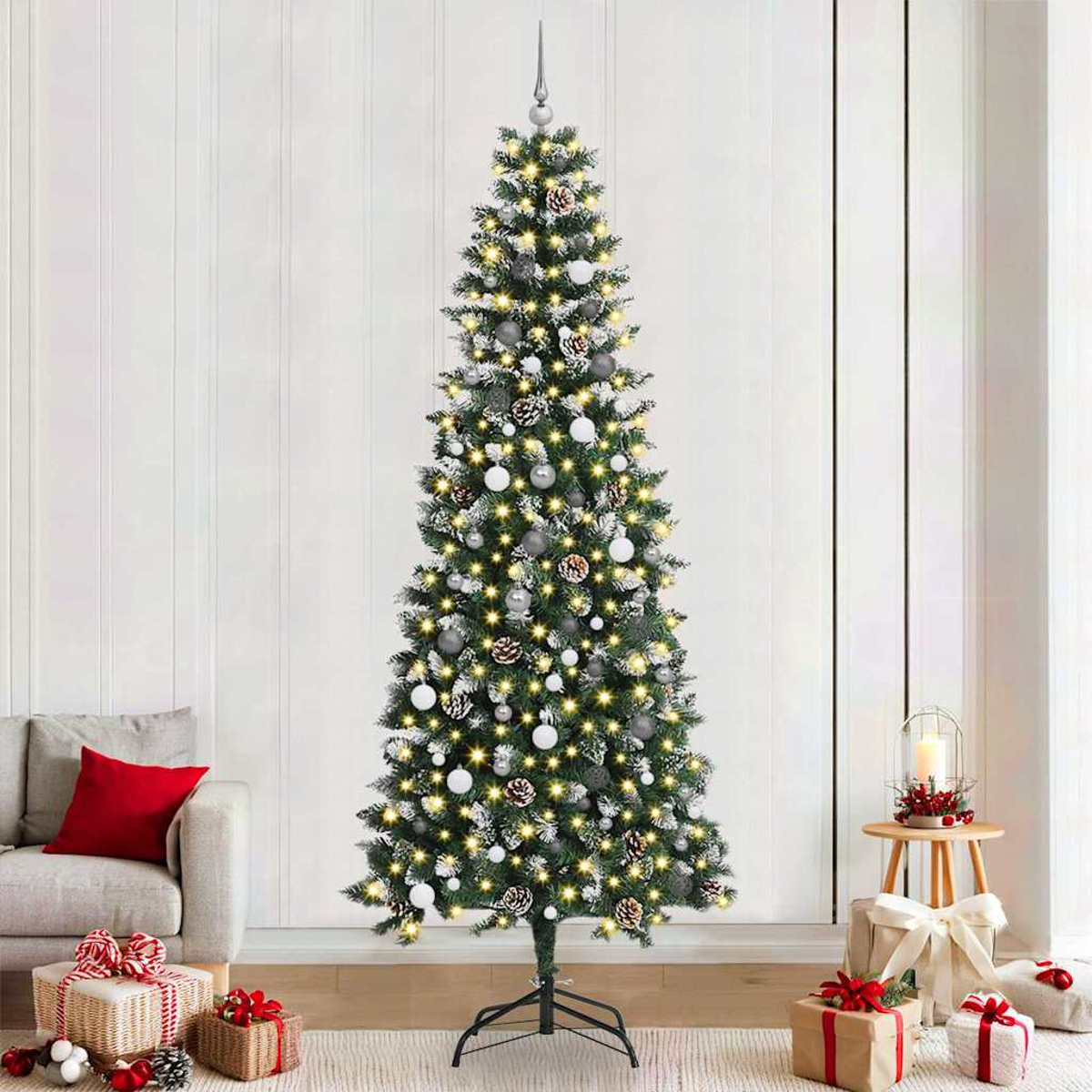Ein geschmückter Weihnachtsbaum steht in einem Wohnzimmer. Er hat Ornamente, Lichter und einen Stern. Geschenke und ein Sofa sind in der Nähe.