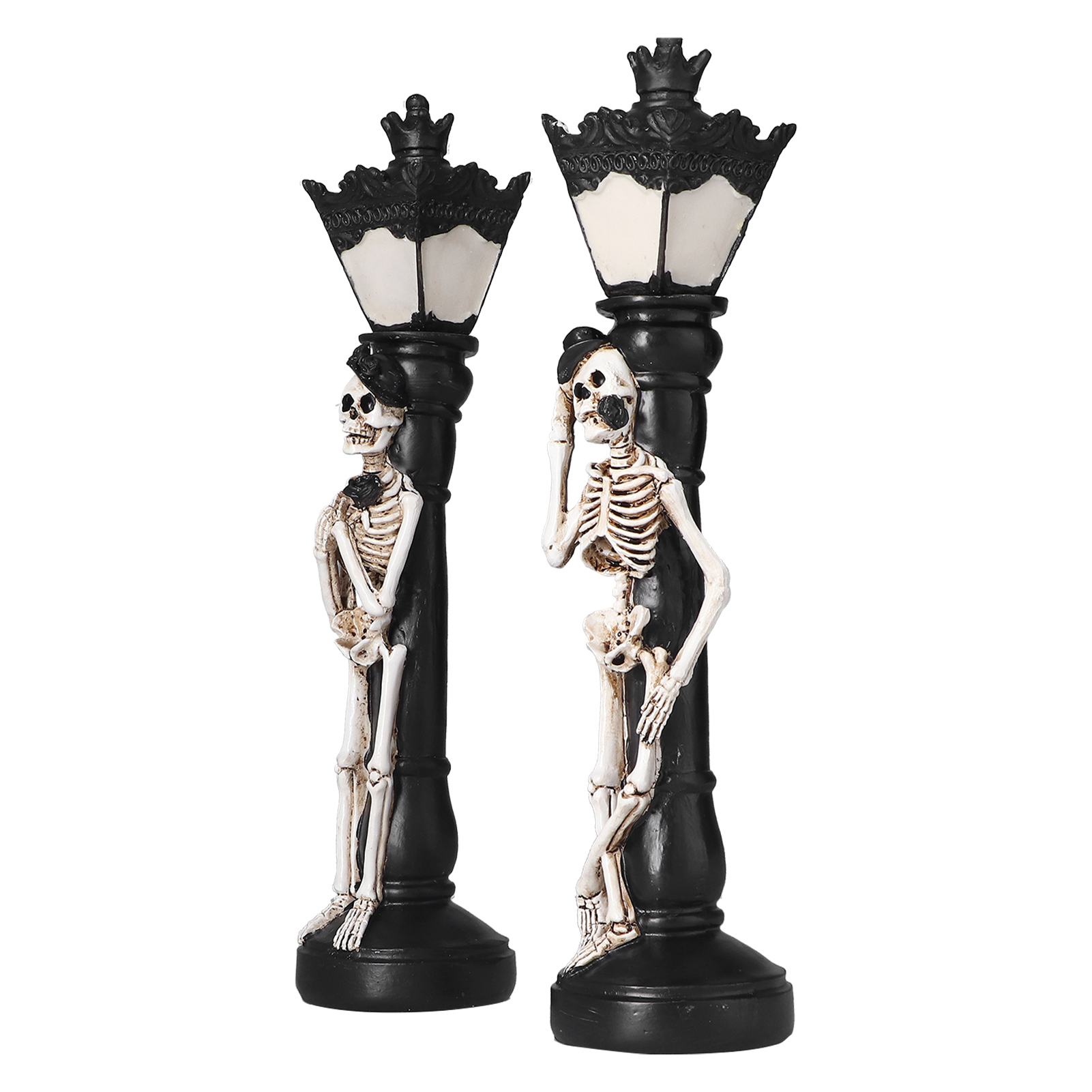 Zwei schwarze Laternenpfähle mit Skeletten in Hüten, die sich darauf abstützen. Die Laternen haben weiße Lampen und verzierte Kronen.