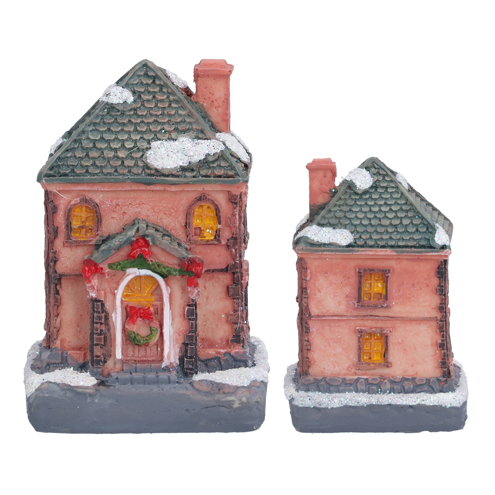 Zwei Miniatur-Ferienhäuser. Eines ist größer, mit einem Weihnachtskranz an der Tür. Beide haben Schnee auf den Dächern.