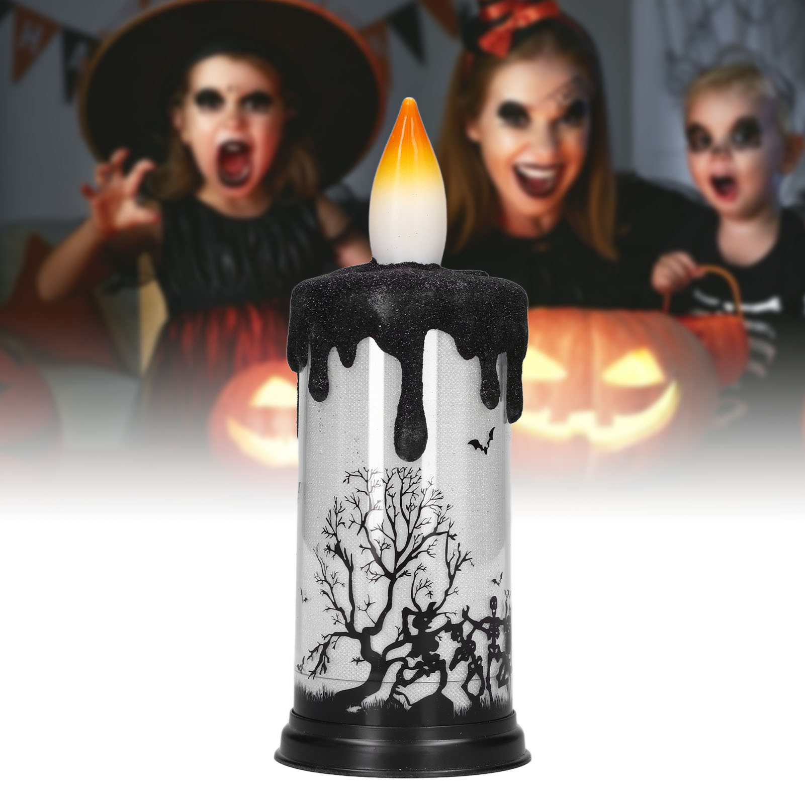 Halloween-Kerze mit schmelzendem schwarzen Wachs, Baum-Silhouette und Kinder in Kostümen im Hintergrund.