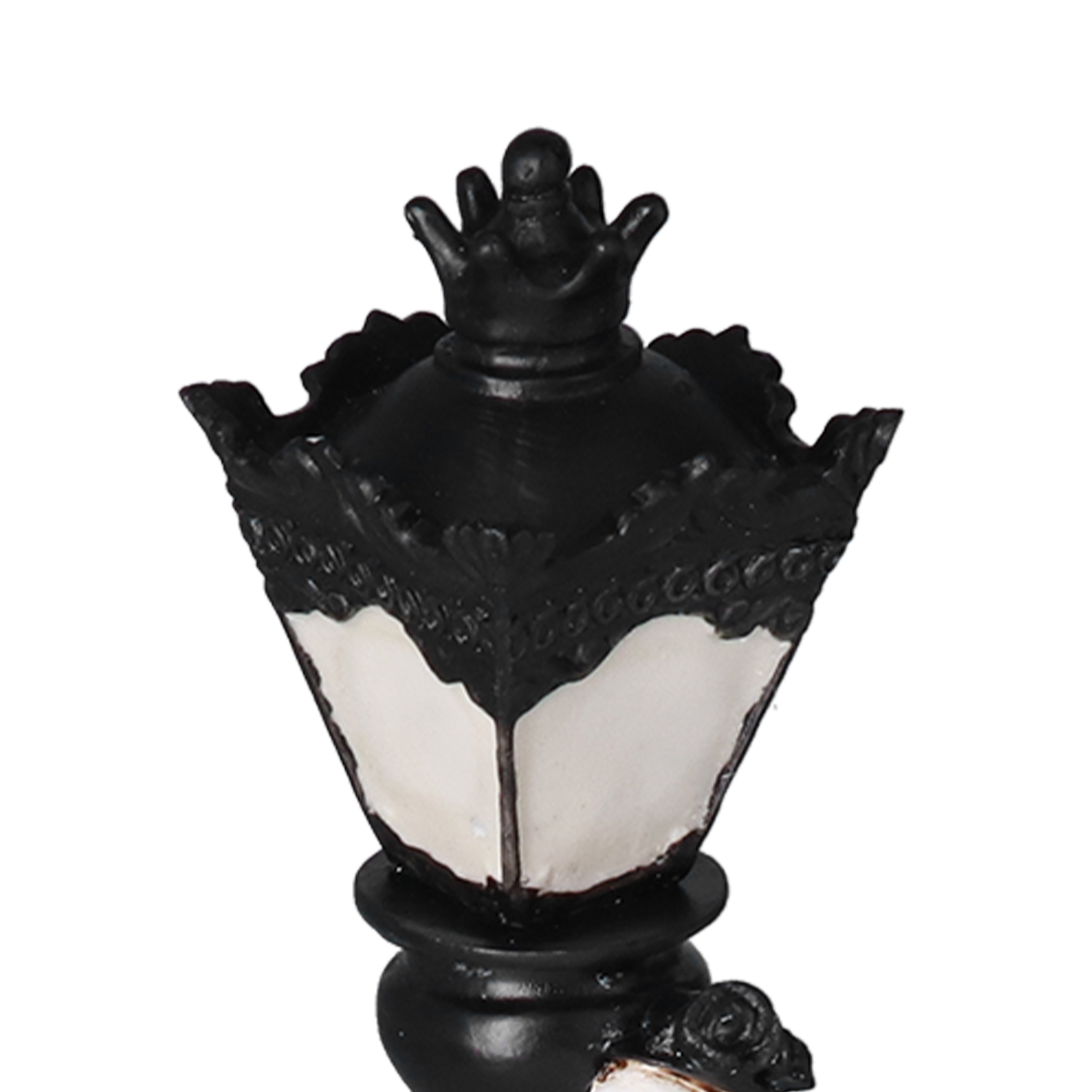 Eine schwarz-weiße Lampe mit kronenartiger Spitze, Zierdetails und einem weißen Lampenabschnitt.